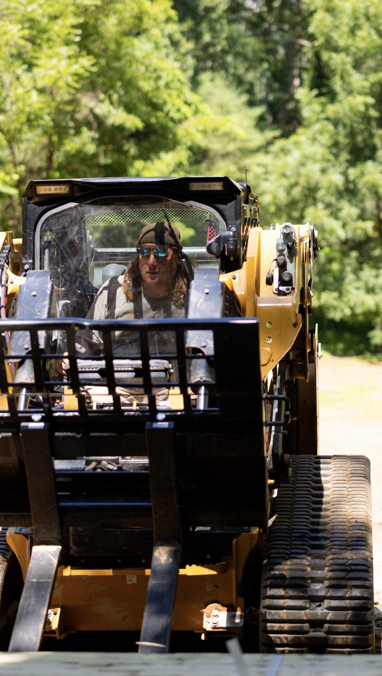 Hazy River Earthworks operating a skid steer for professional excavation, grading, and site preparation in Western North Carolina.