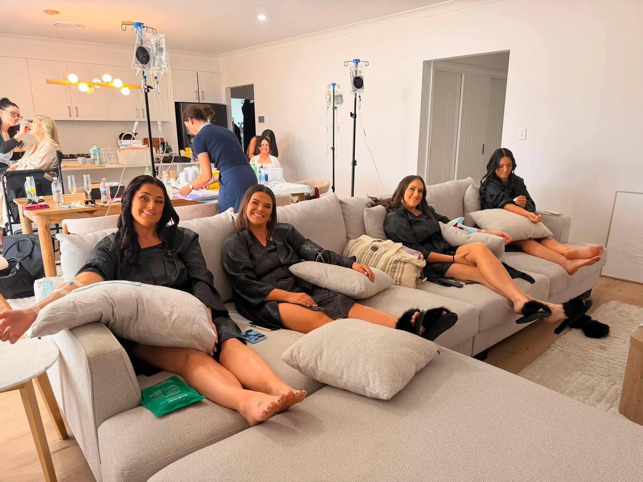 Four girls in preparation of the wedding day are set up with IV Therapy in action and RN Natalie Bell opf Infinity Infusions is in the background setting up.