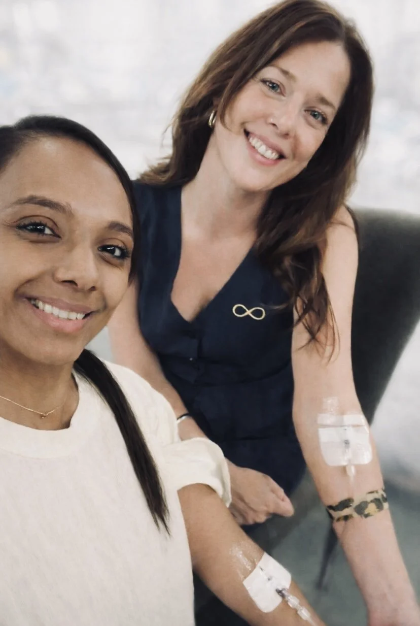 Founder Natalie Bell with a happy client receiving injections in the arm at the clinic