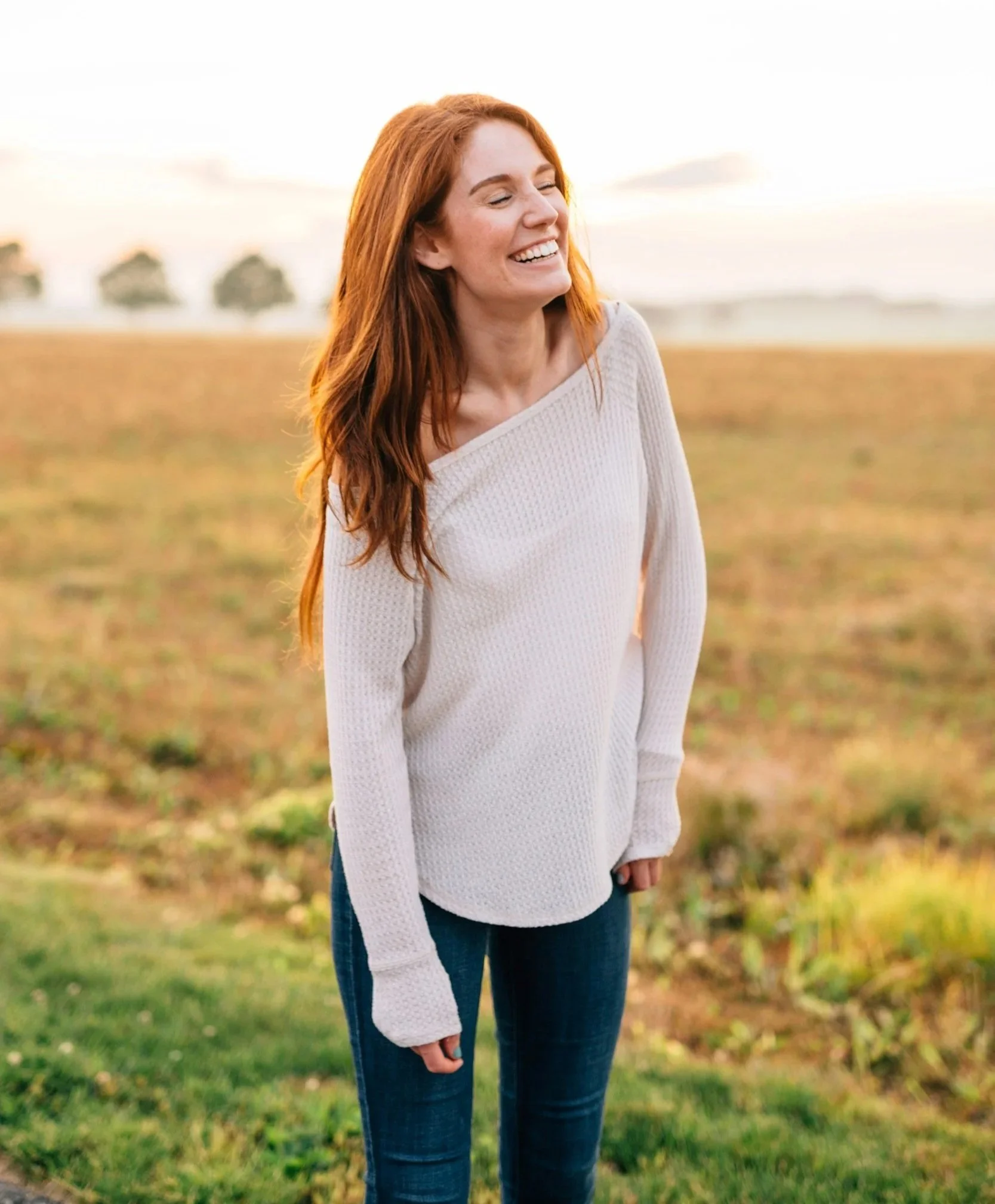 Woman smiling in a field.