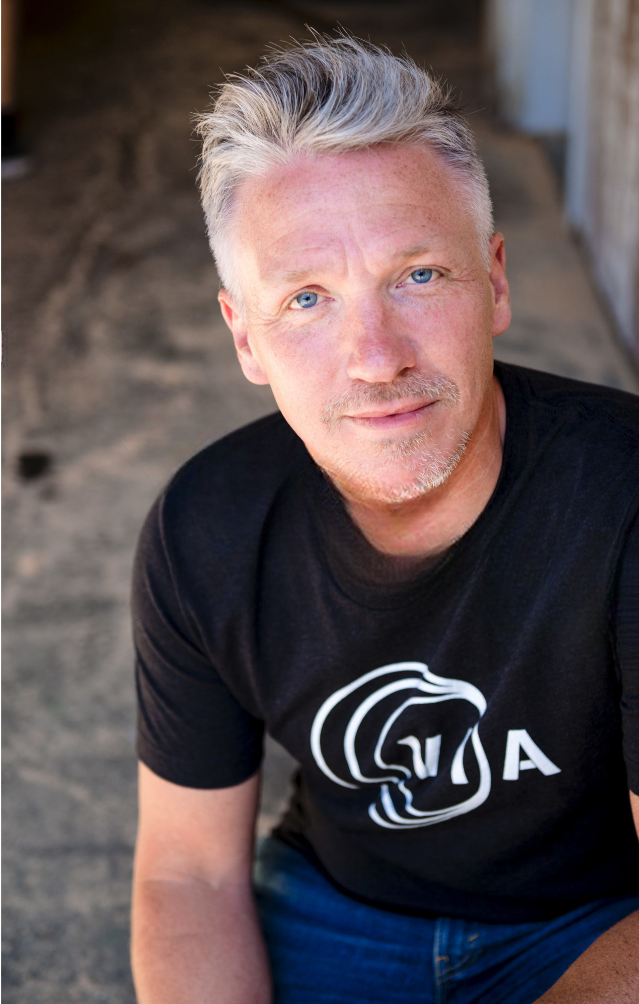 Rob Bowker wearing a black T-shirt with a VIA logo.