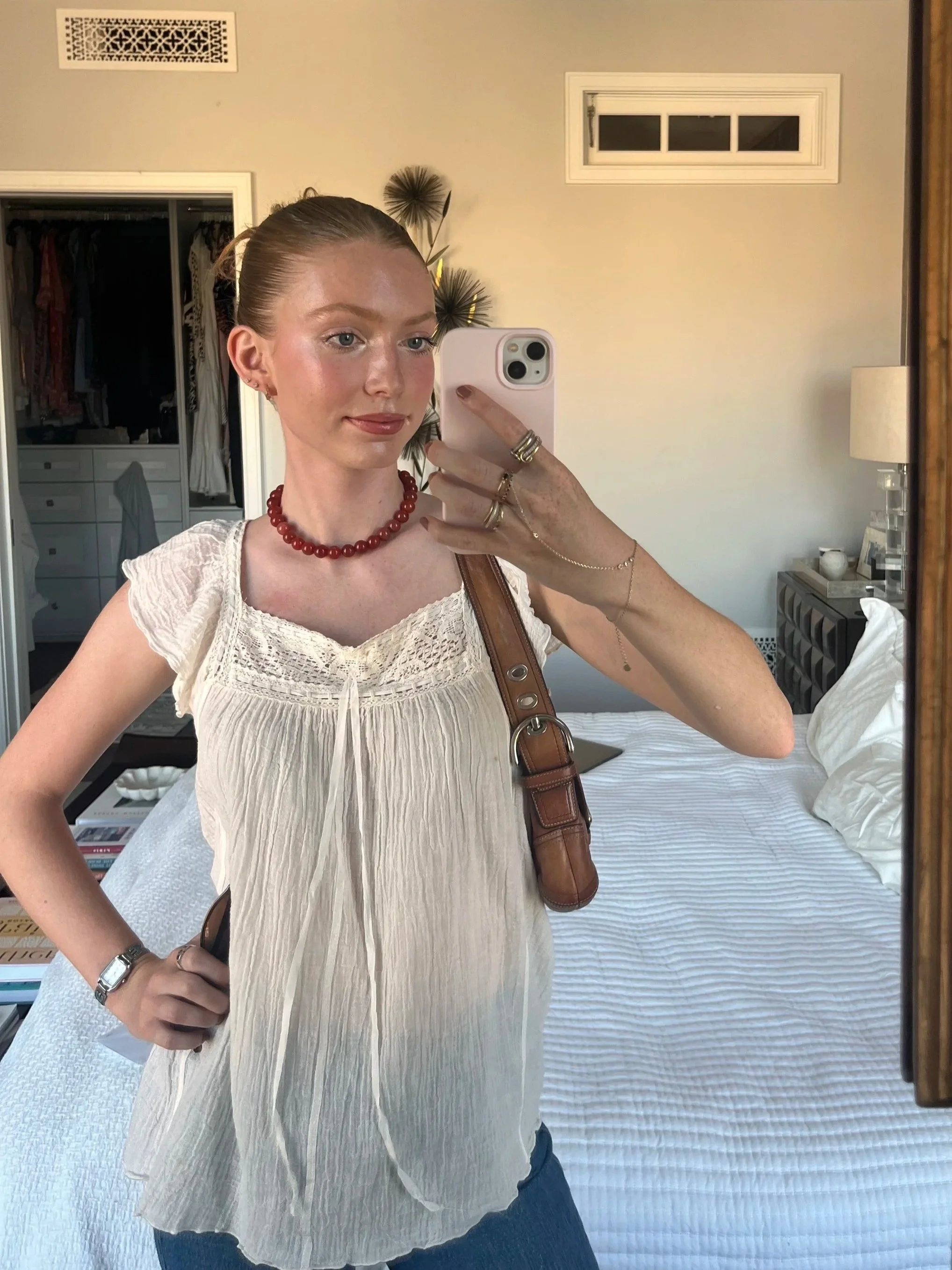 Woman styling the red Anya choker in a mirror selfie.