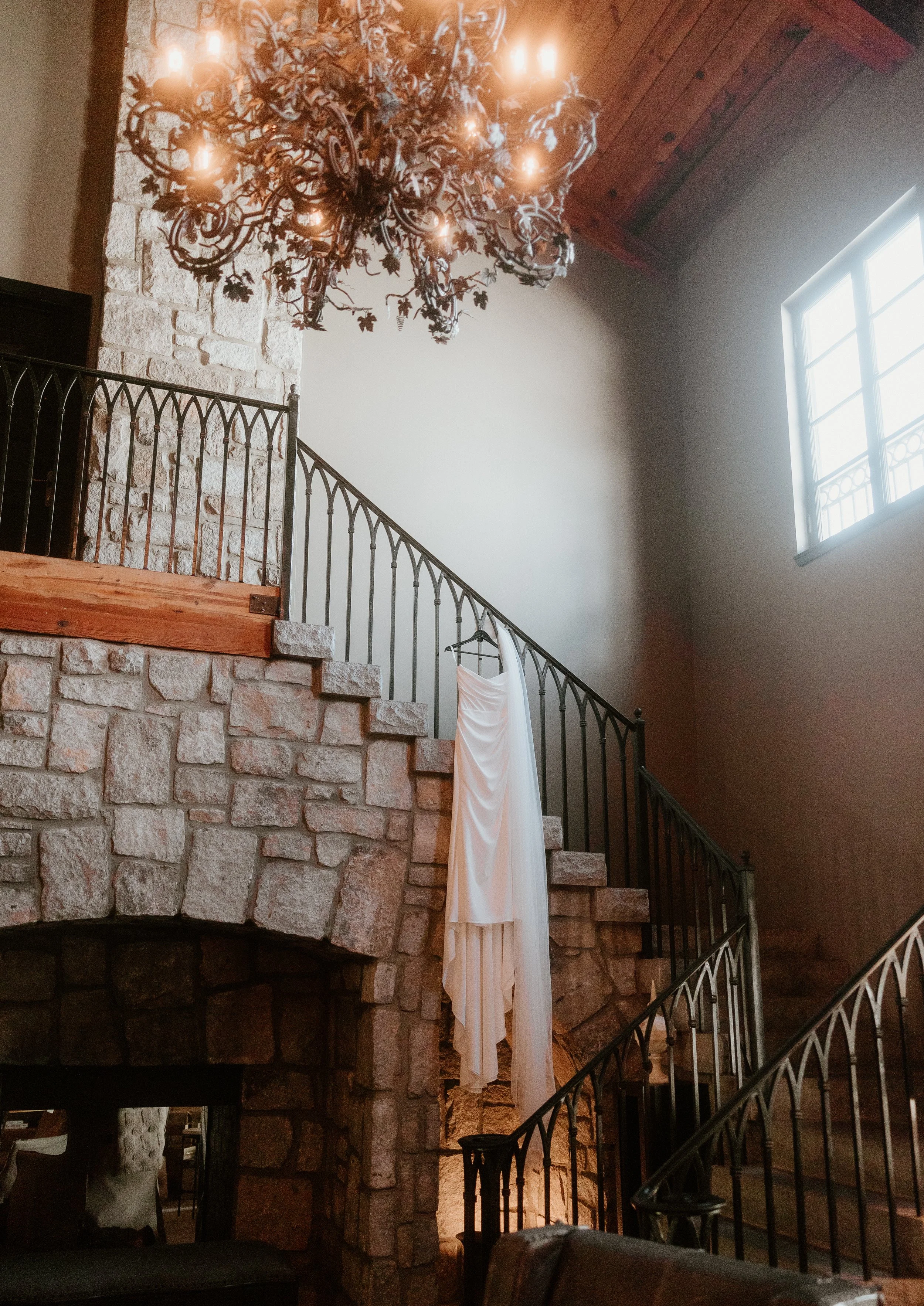 wedding dress hanging on staircase with elegant bridal details