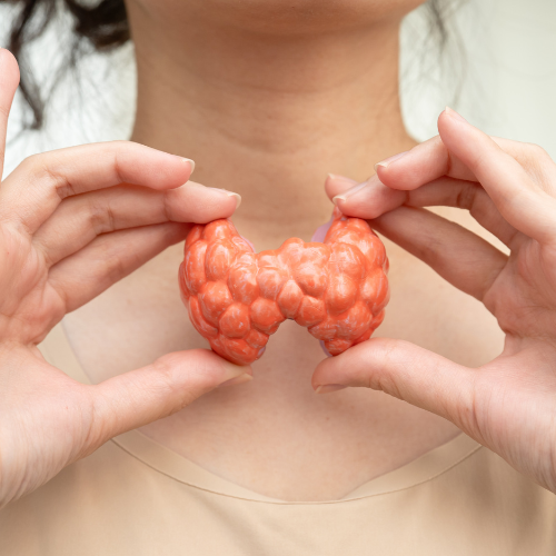 Person holding a brain-shaped object made of orange material.