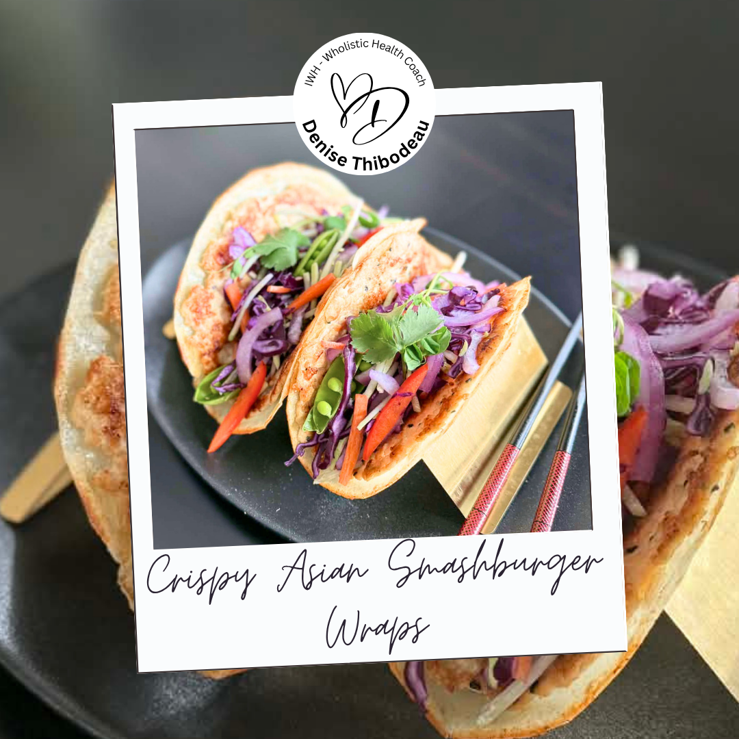 Three Asian-inspired crispy smashburger wraps filled with colorful vegetables including purple cabbage, carrots, snap peas, and garnished with cilantro, served on a black plate with chopsticks and a decorative paper overlay.