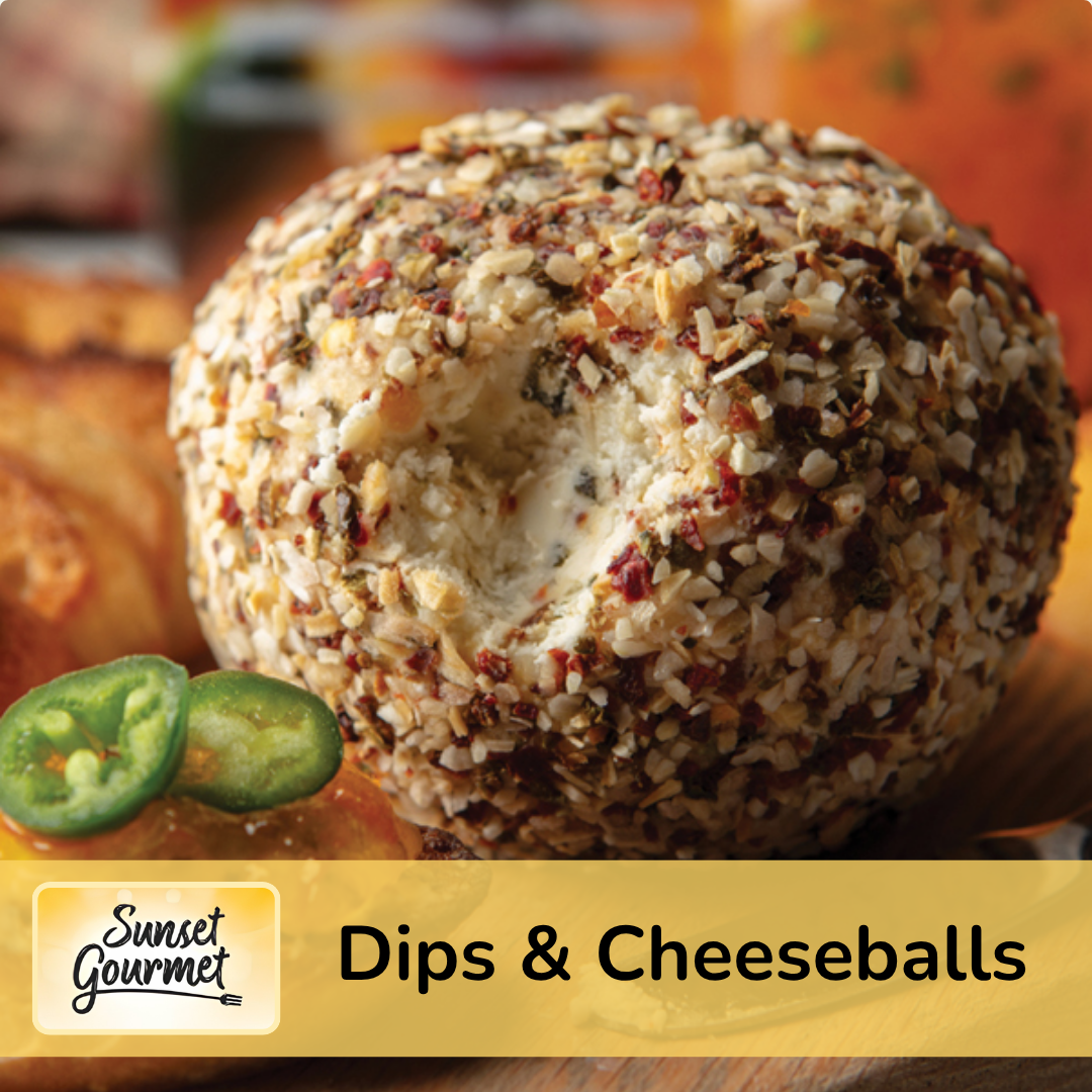 A close-up of a breaded cheese ball covered in chopped nuts surrounded by sliced jalapeños and other appetizers with a blurred background.