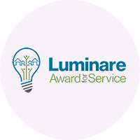 Luminaire Award & Service logo with a lightbulb design and blue and green text