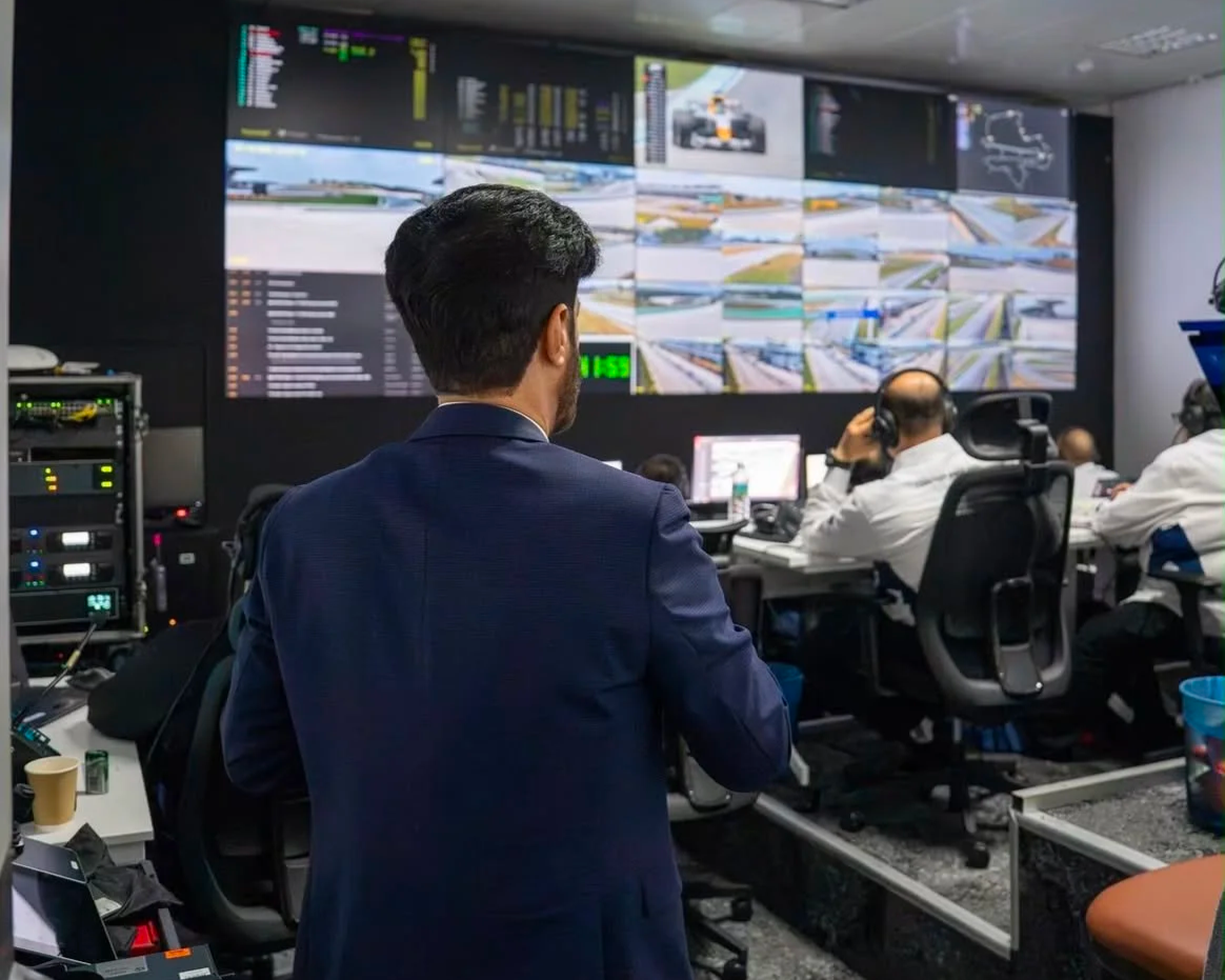 FIA personnel monitoring multiple race screens in race control as Mohammed Ben Sulayem looks on.