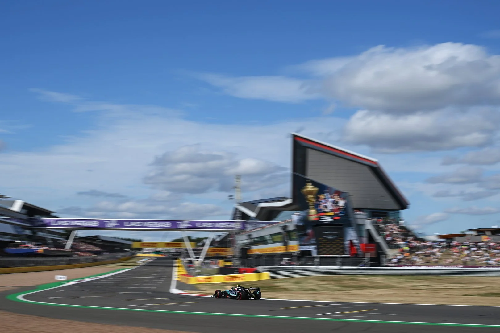 A Mercedes Formula 1 car racing past the Silverstone Wing during the 2026 British Grand Prix weekend.