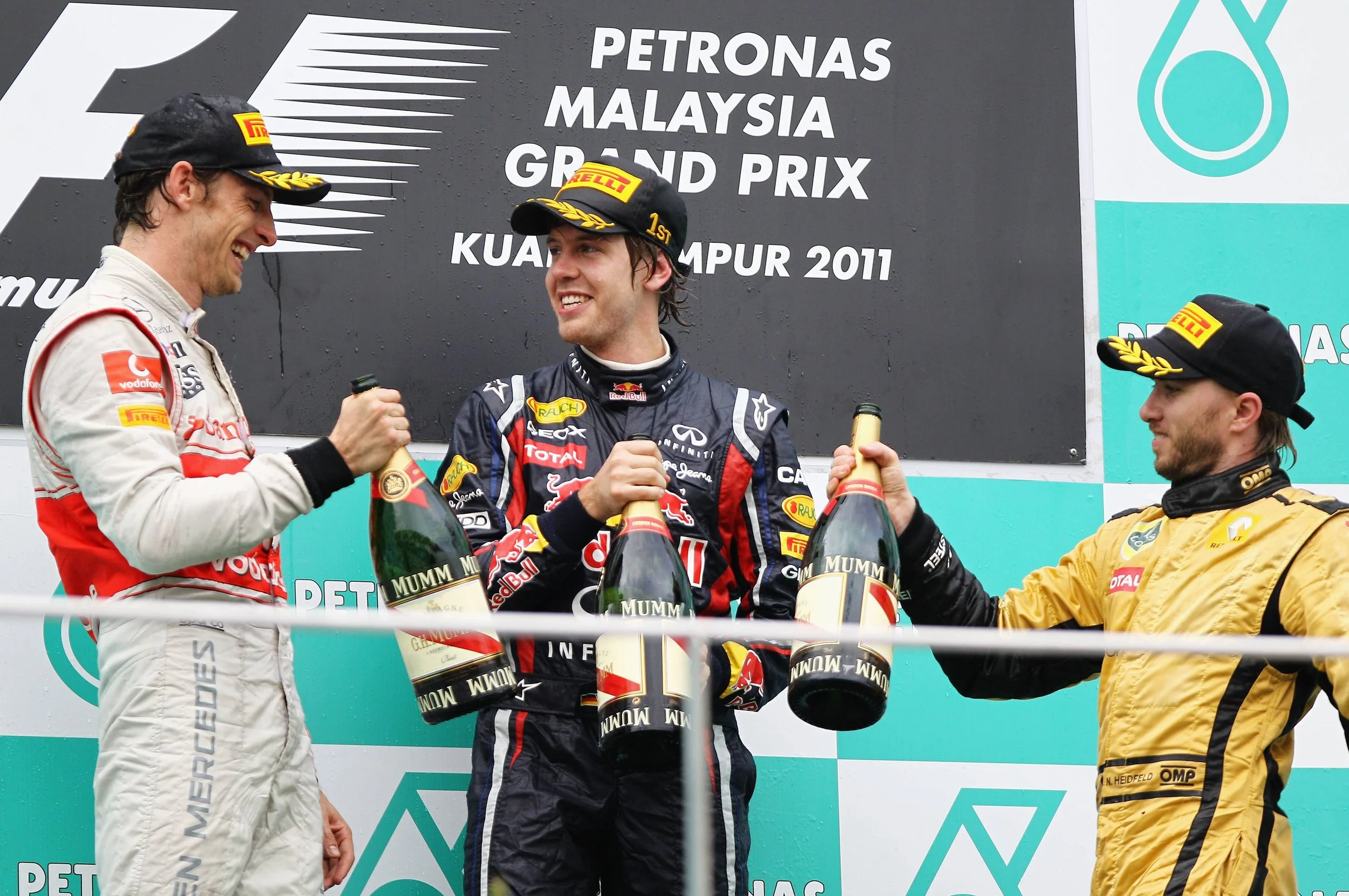 Sebastian Vettel, Jenson Button and Nick Heidfeld celebrating on the podium at the 2011 Malaysian Grand Prix.