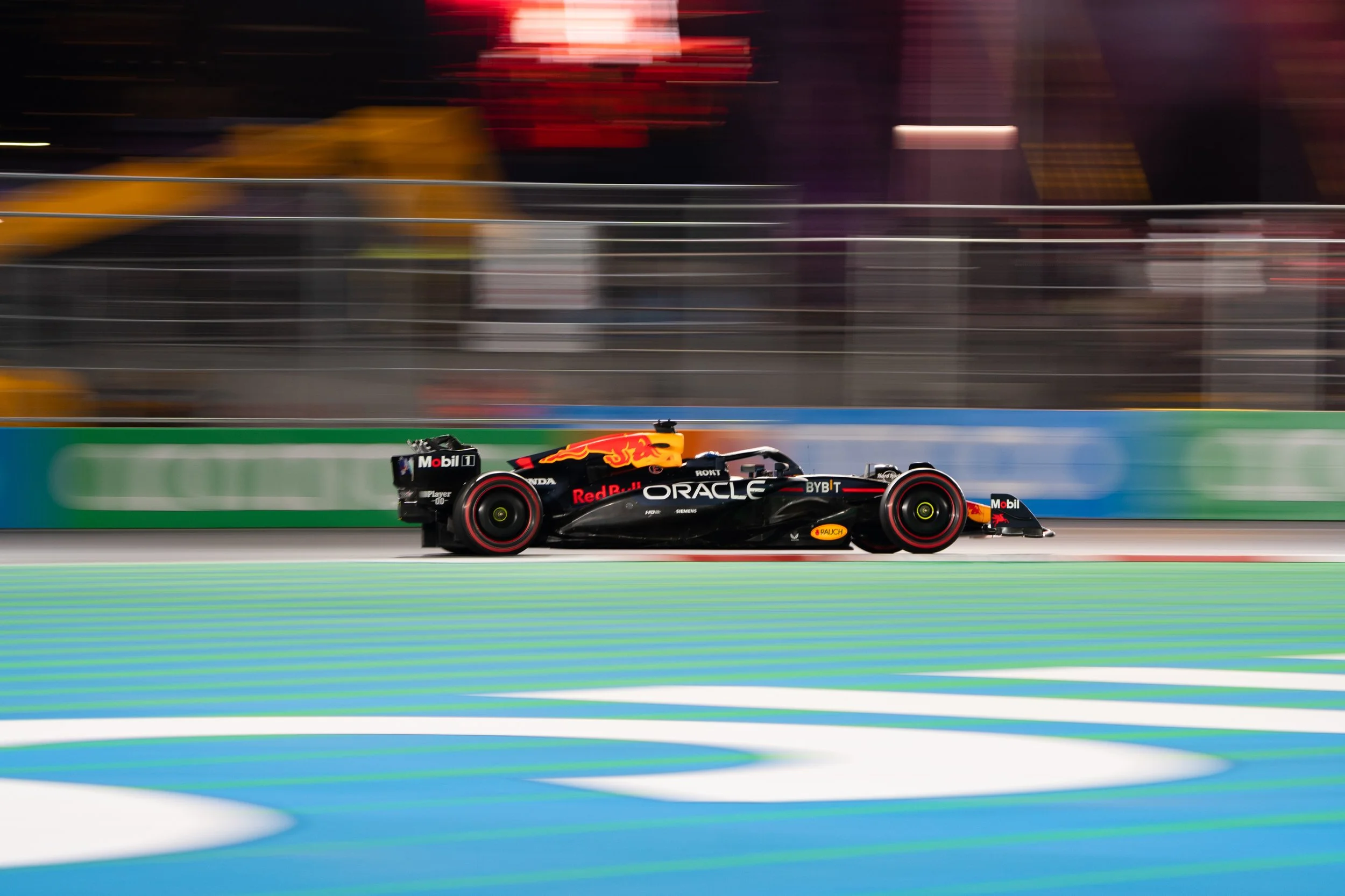 Max Verstappen race car on at night race at Formula 1 Las Vegas Grand Prix with motion blur in the background in front of the Las Vegas Sphere.