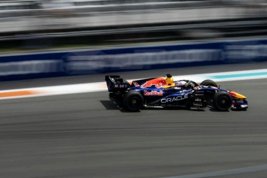 A Formula 1 race car speeding on a race track, featuring Red Bull Racing livery with Oracle sponsorship and Red Bull logo.