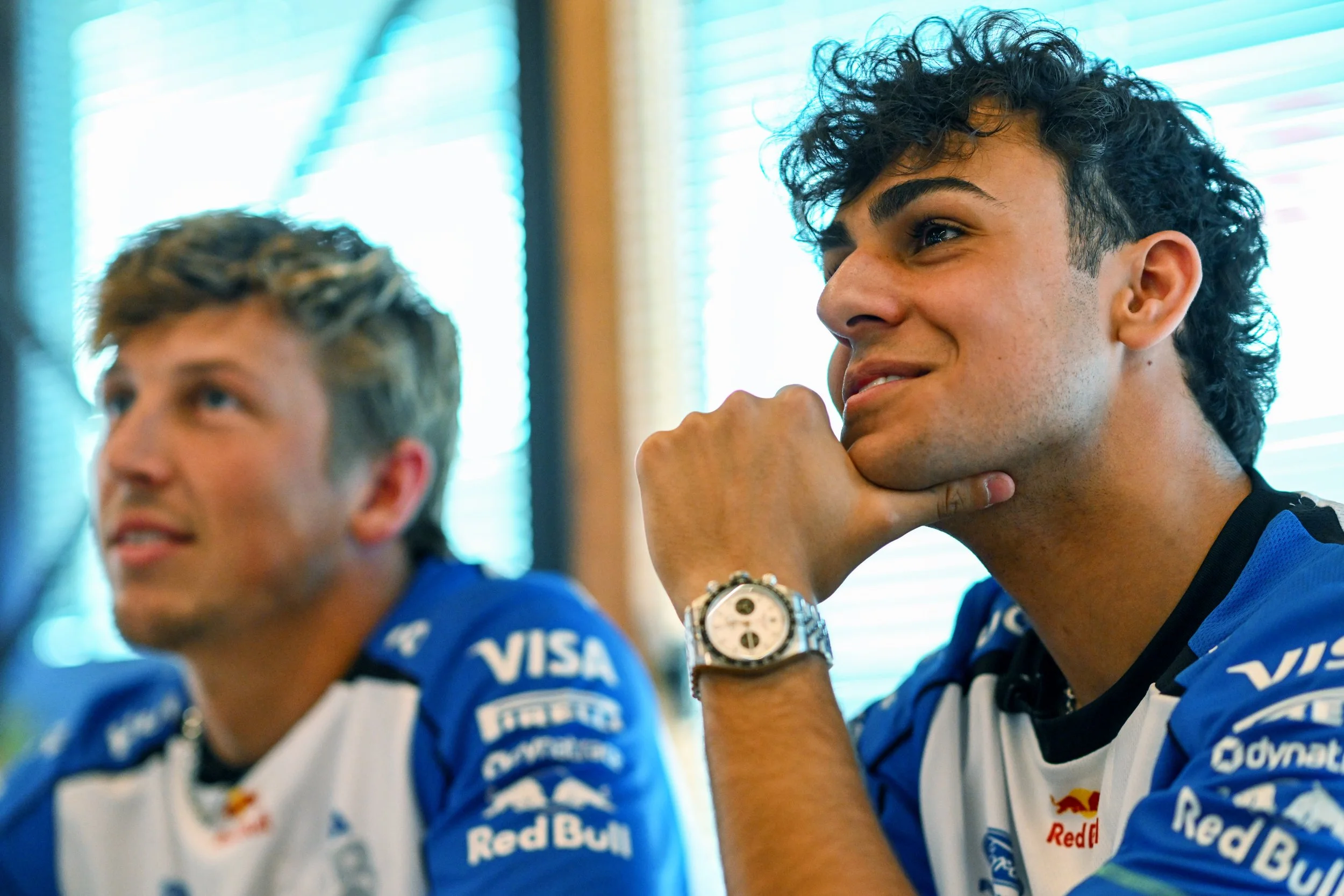 Racing Bulls team members listen during a Formula 1 race weekend media session.