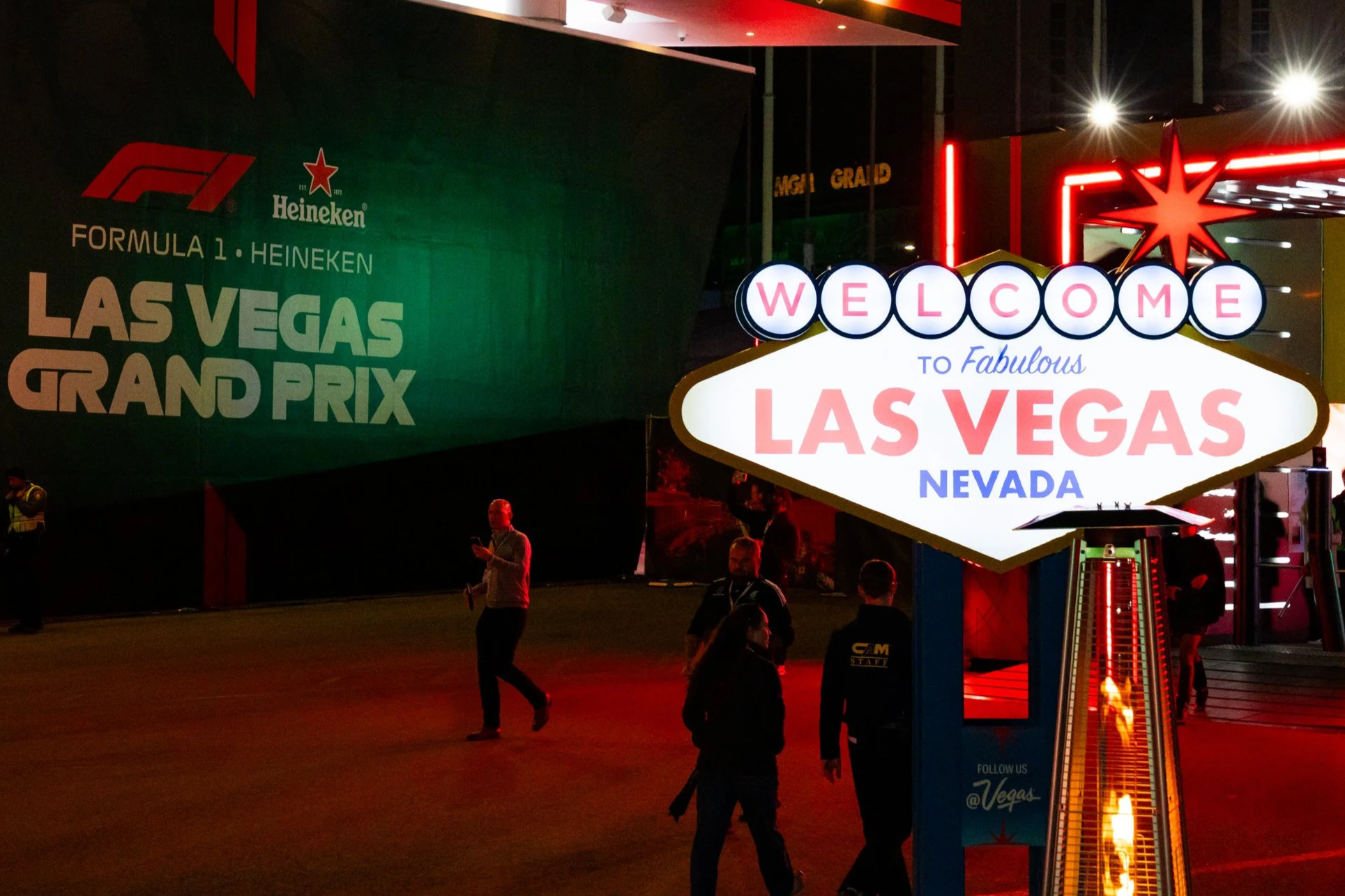 Nighttime scene at Las Vegas with illuminated Welcome sign and large Green banner promoting Formula 1 Heineken Grand Prix.