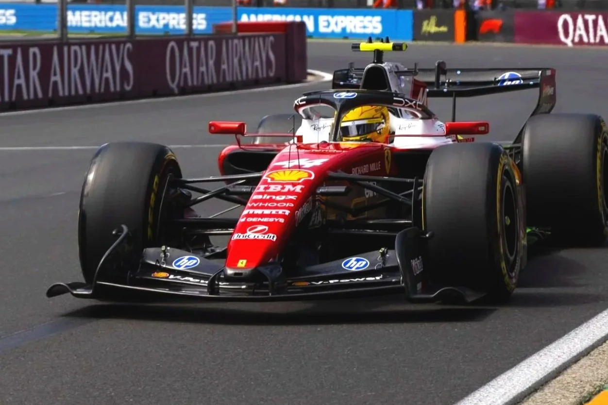 A Formula 1 race car with a red and black livery on a racetrack, with sponsorship logos including Shell, HP, and Ferrari.