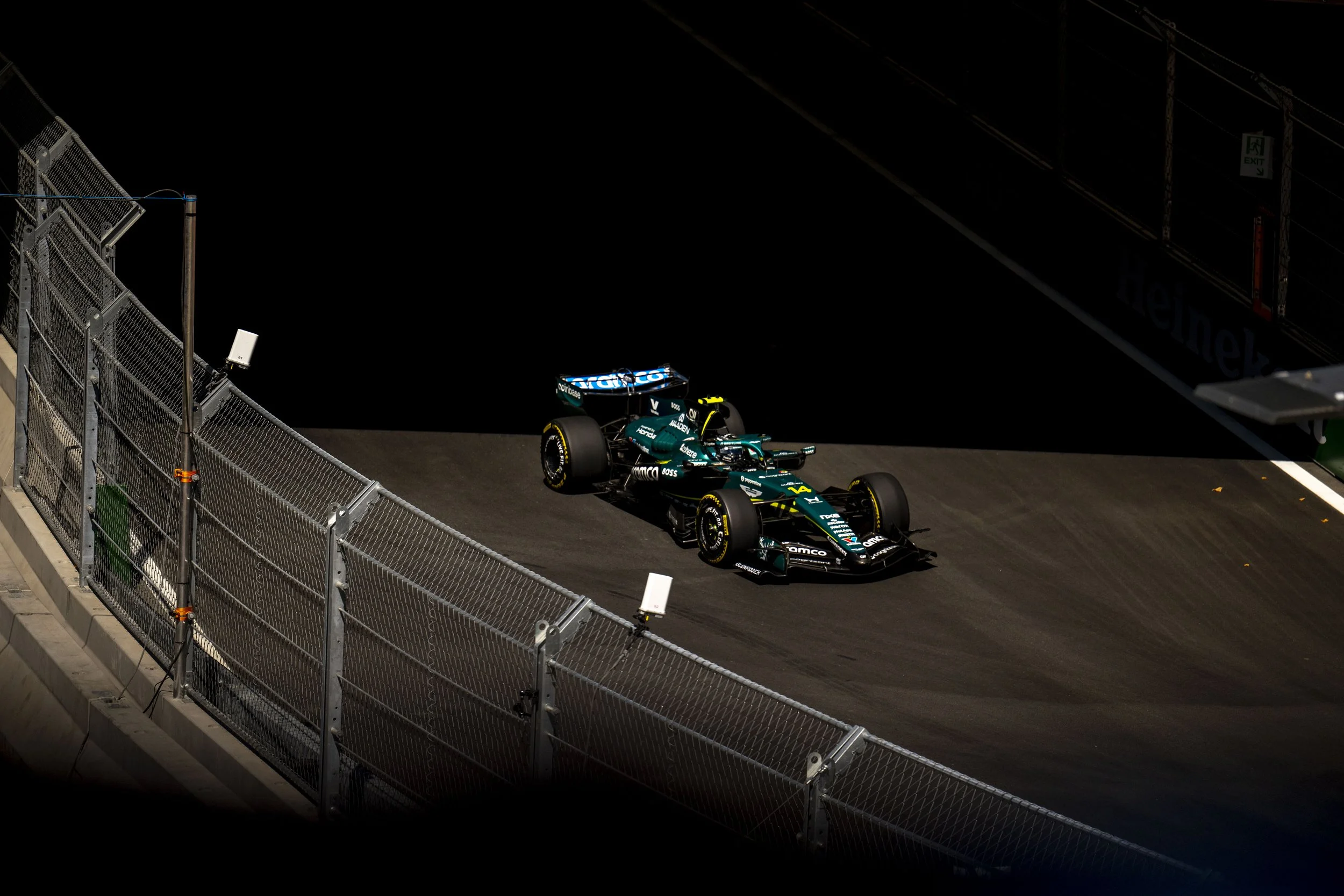 Fernando Alonso driving the Aston Martin Formula 1 car through a banked corner at MADRING