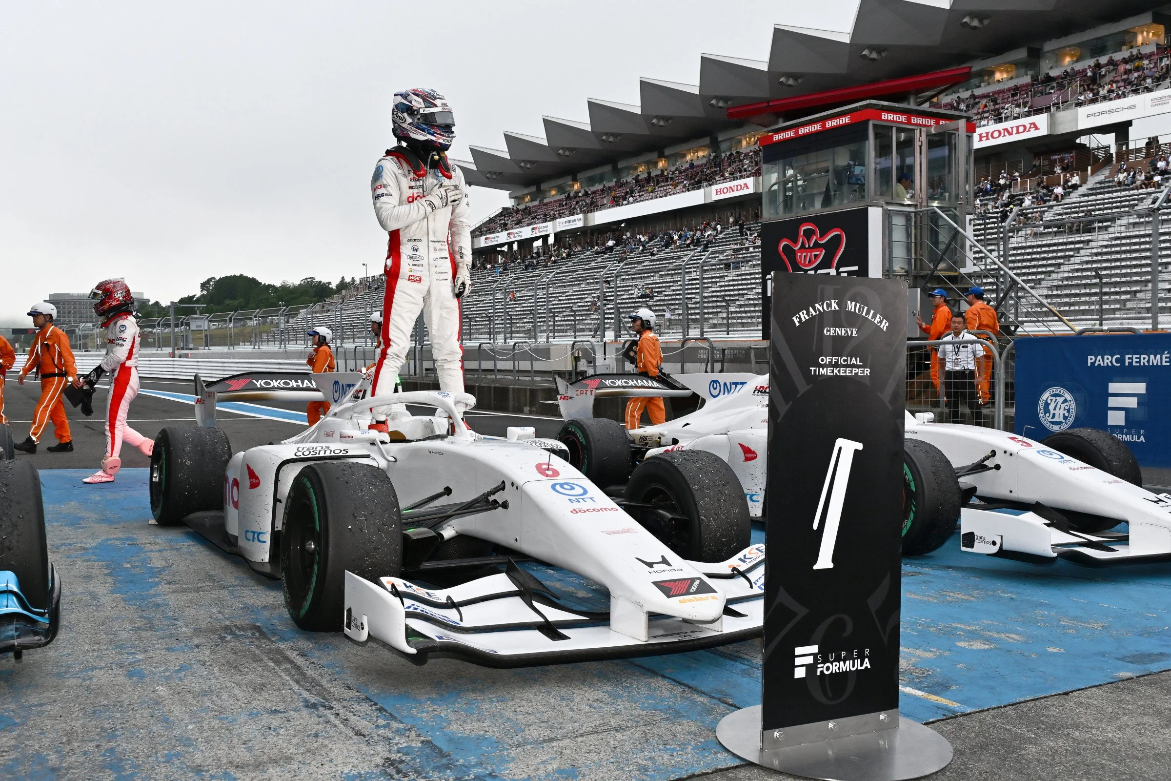 Kakunoshin Ohta stands on his No. 5 Dandelion Racing car after winning a Super Formula race.