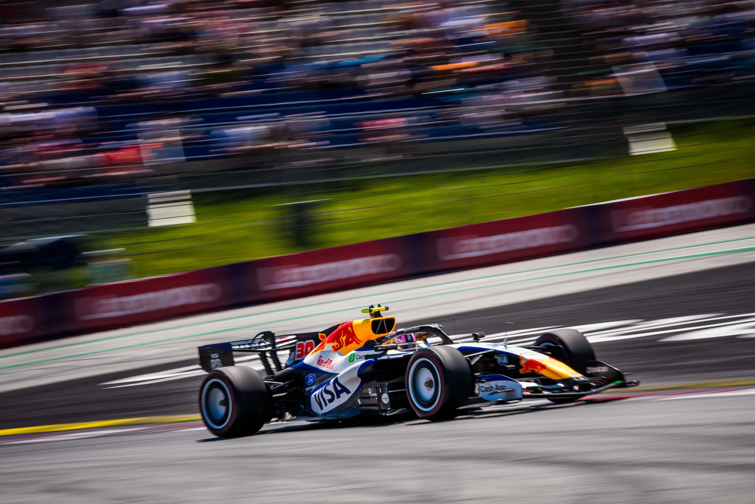 Racing Bulls Formula 1 car speeds past the grandstand during the 2026 season.