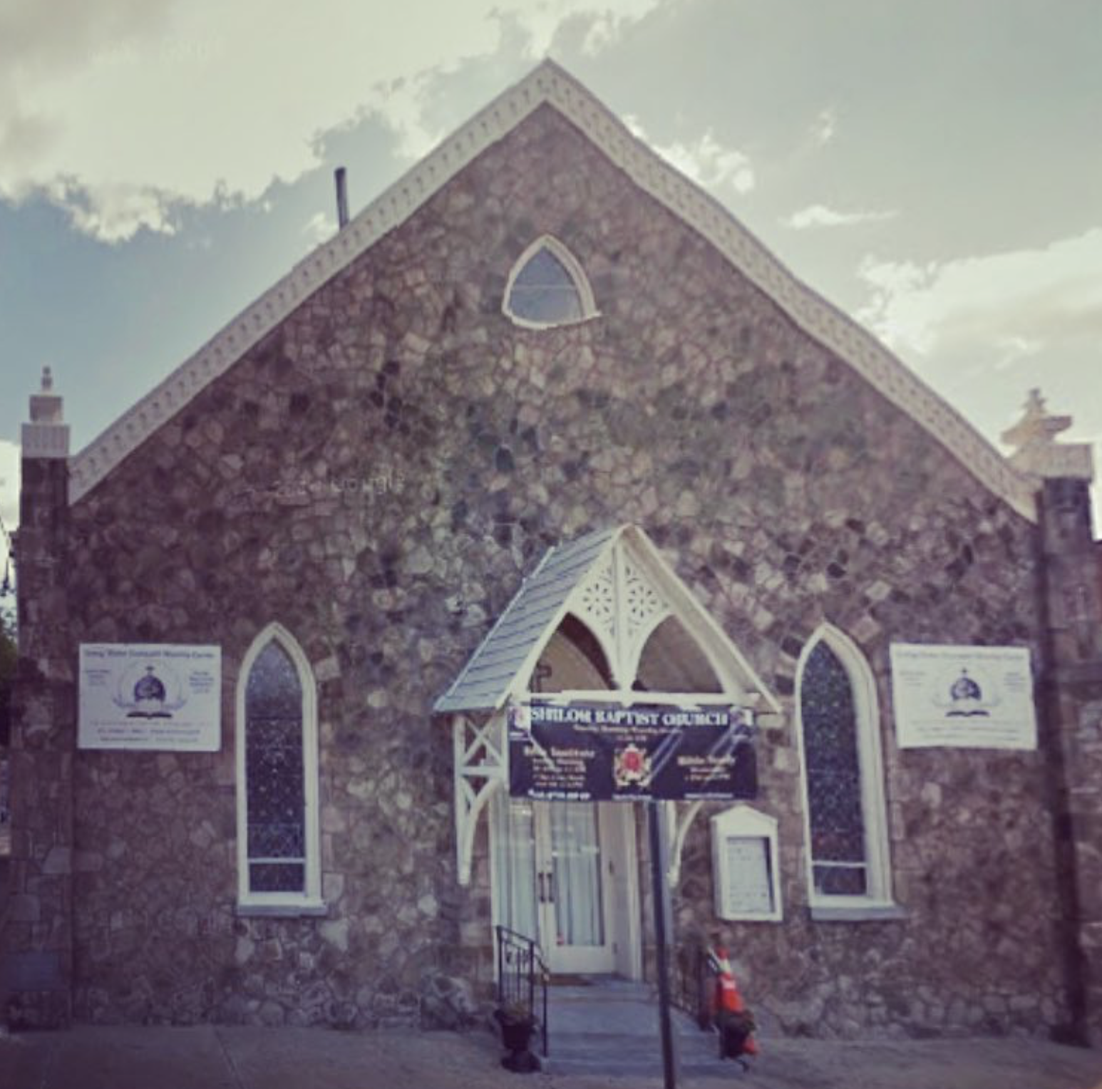 Stone church with arched windows, white trim, and a sign above the entrance that reads 'The Lord Baptist Church'.