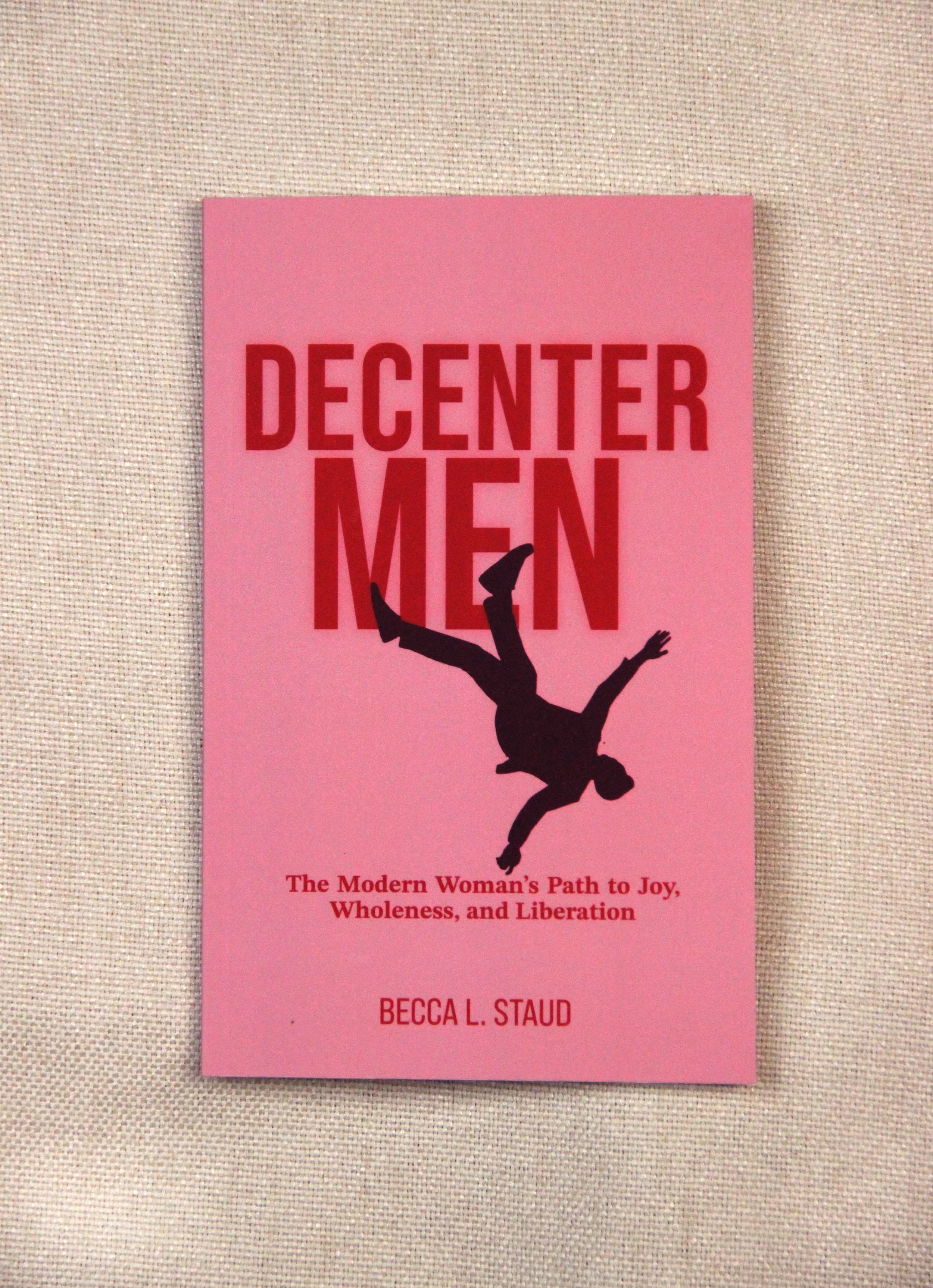 Pink book cover titled "Decenter Men" with a silhouette of a person falling or flipping, and the subtitle "The Modern Woman's Path to Joy, Wholeness, and Liberation" by Becca L. Staud.