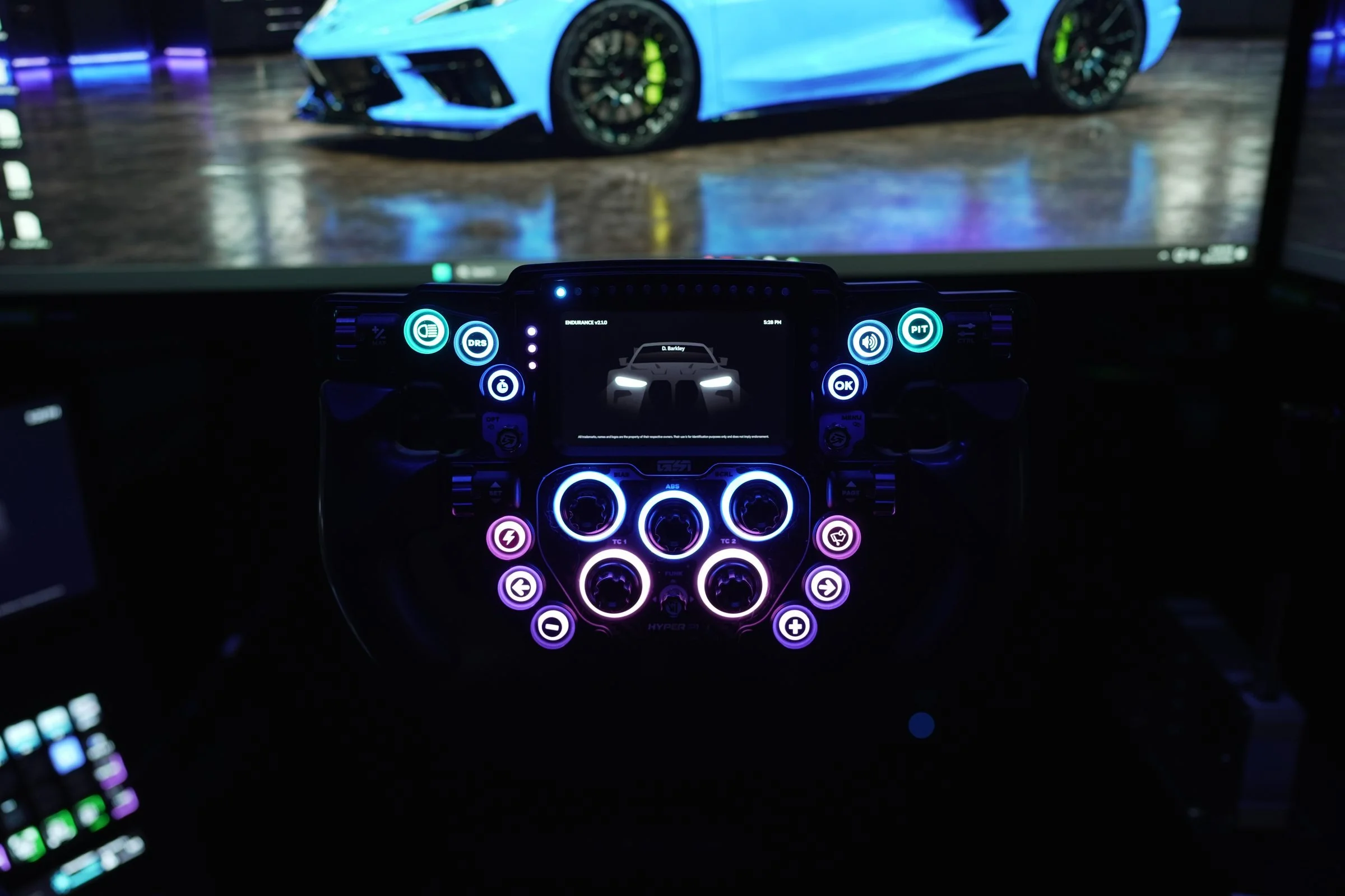 GSI Hyper P1 sim racing wheel in front of a monitor showing a blue Corvette