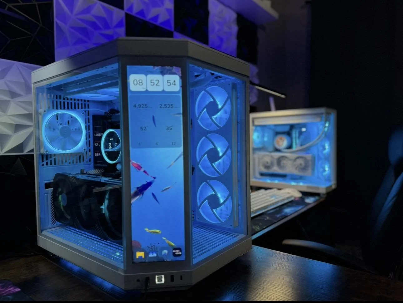 A custom-built gaming computer with a transparent case illuminated by blue LED lights. The interior components, including cooling fans and a graphics card, are visible through the case.