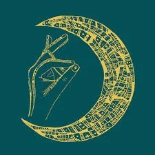 Une petite maison moderne en bois avec une grande fenêtre, située dans un paysage de montagnes et de végétation sèche.