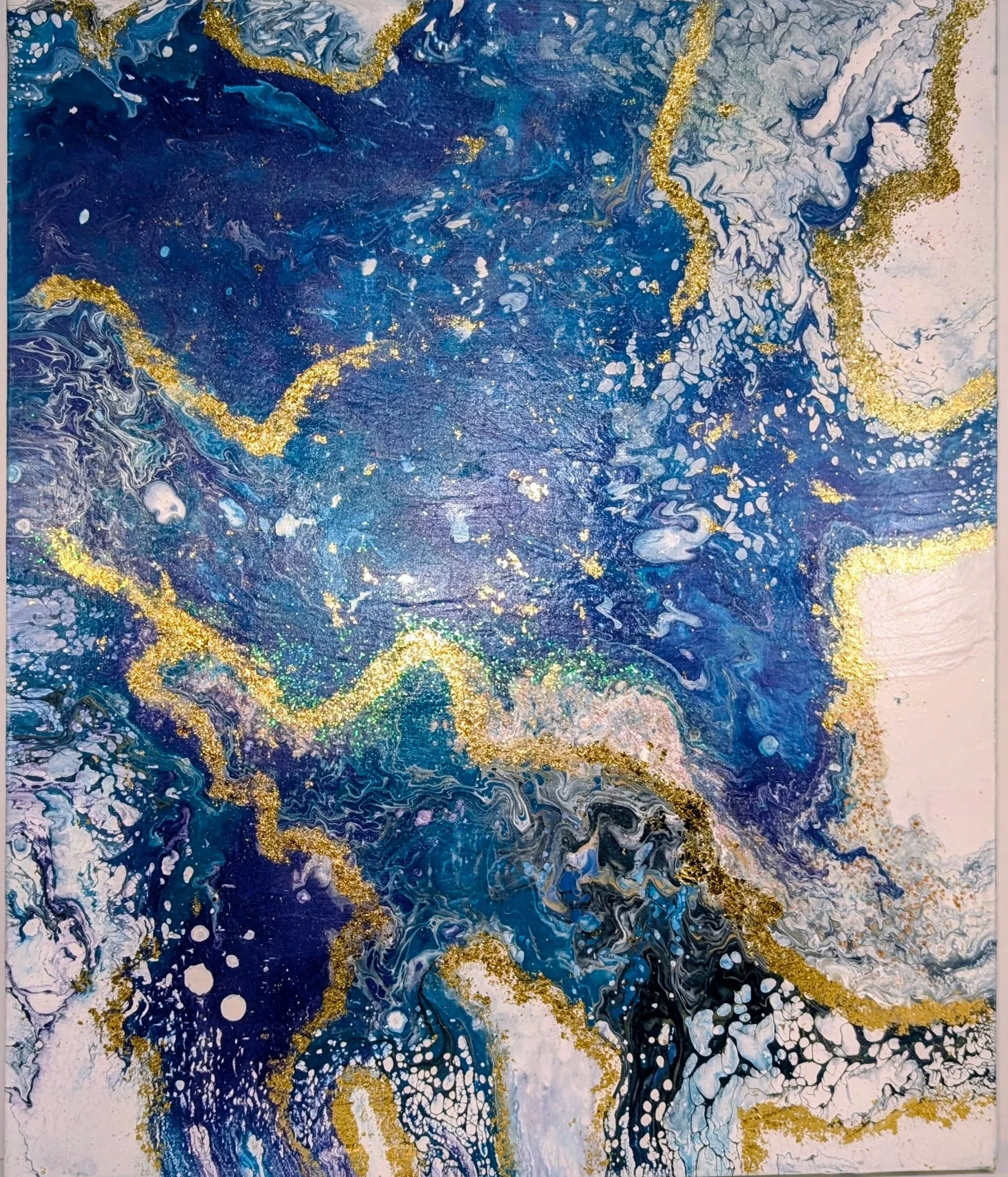 Abstract painting with swirling shades of blue, white, black, and gold accents.