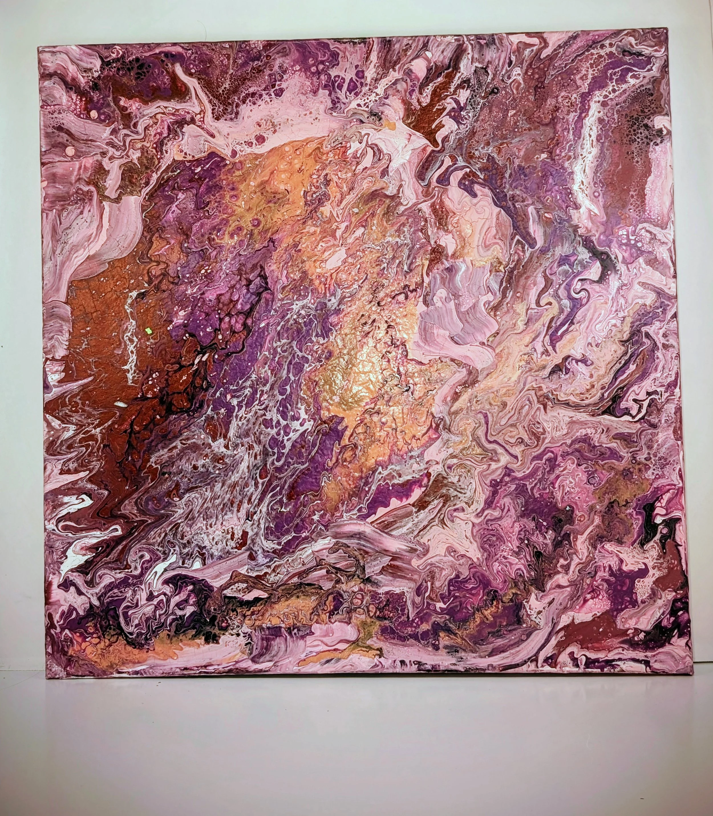Abstract acrylic painting with swirls of pink, purple, gold, black, and white colors.