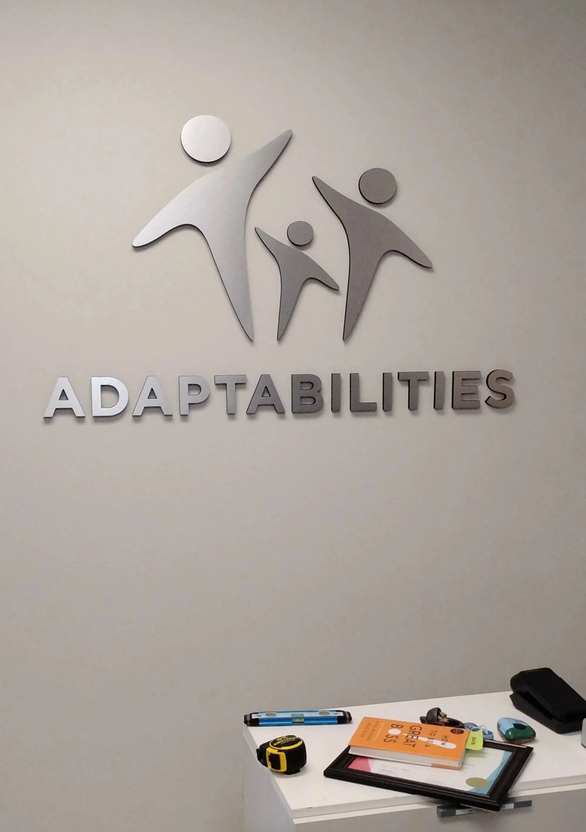 Stand-off sign at the reception desk of Adaptabilities new south Edmonton office.