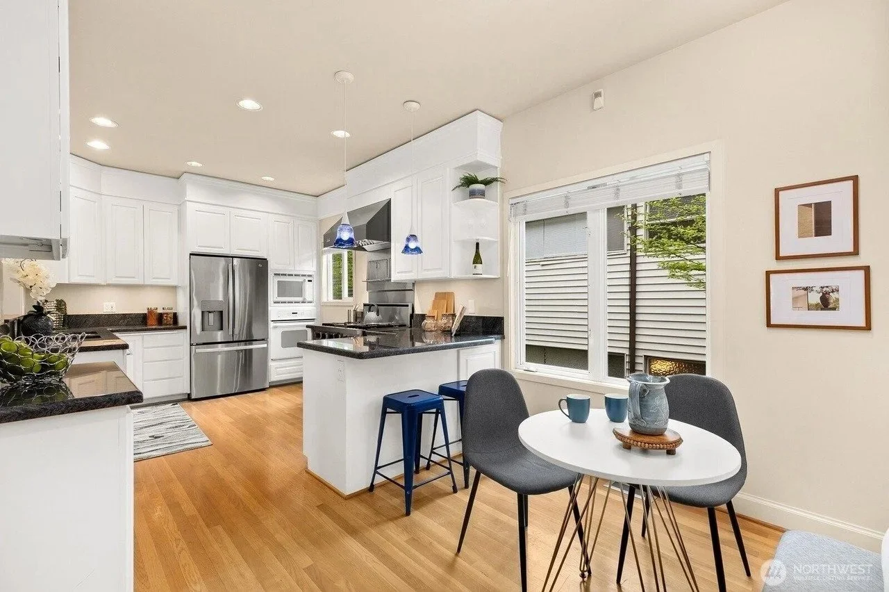 Staged kitchen with breakfast table and white cabinetry in a Madison Park townhouse, Seattle