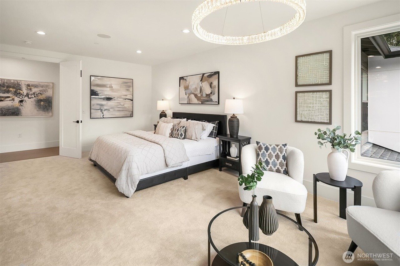 Staged primary bedroom with sitting area and soft neutral decor in a Rose Hill transitional home, Redmond
