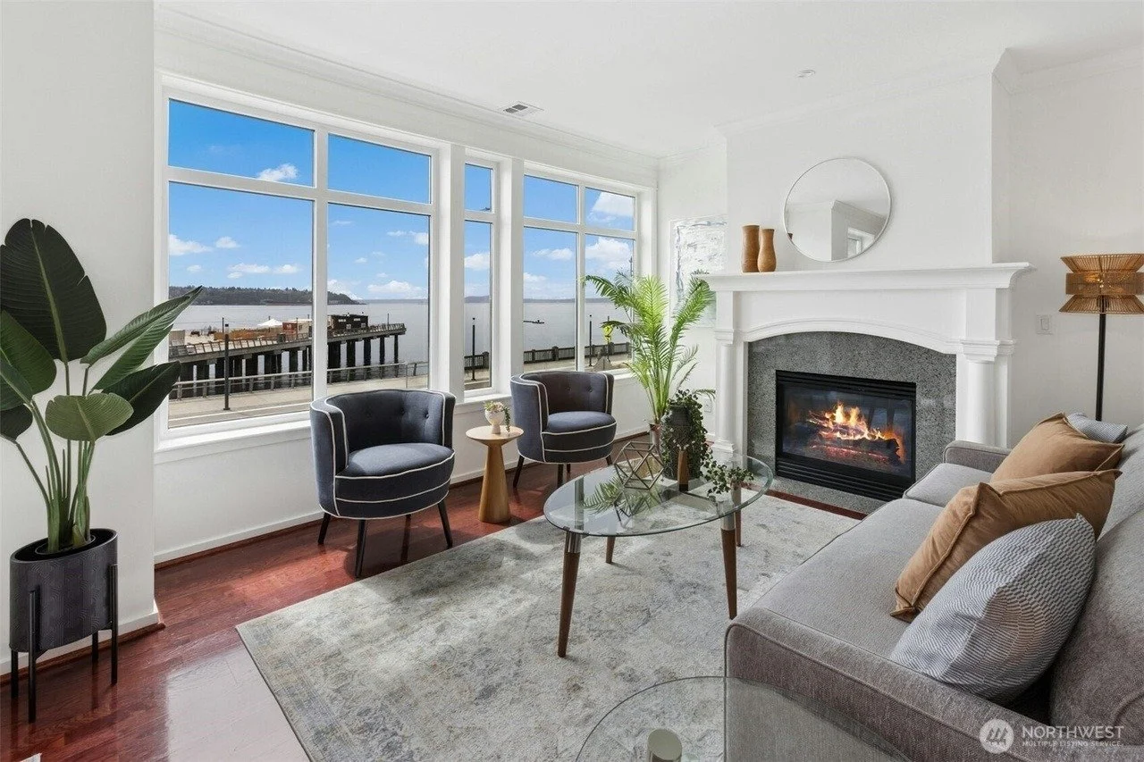 Staged living room with fireplace and water-view windows in a Seattle waterfront condo