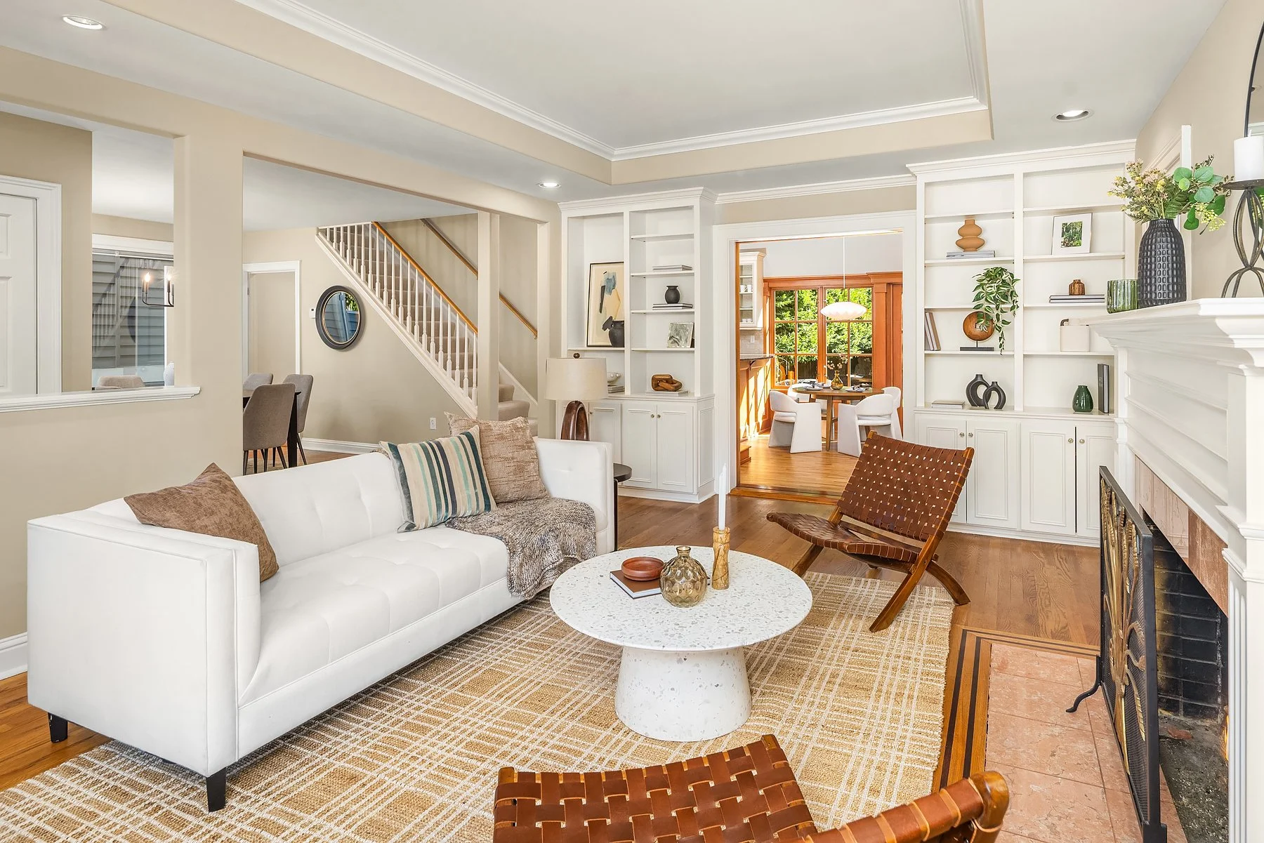 Staged Madison Park living room in Seattle with a white sofa, a round stone coffee table and built-in shelves