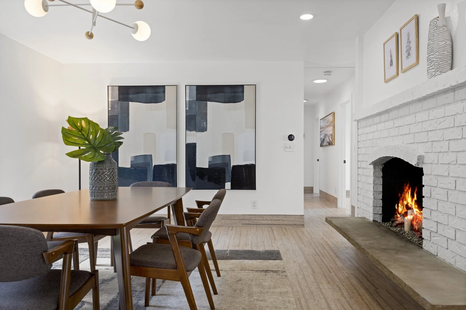 Staged dining area beside a white brick fireplace in a modern rambler, Bow WA