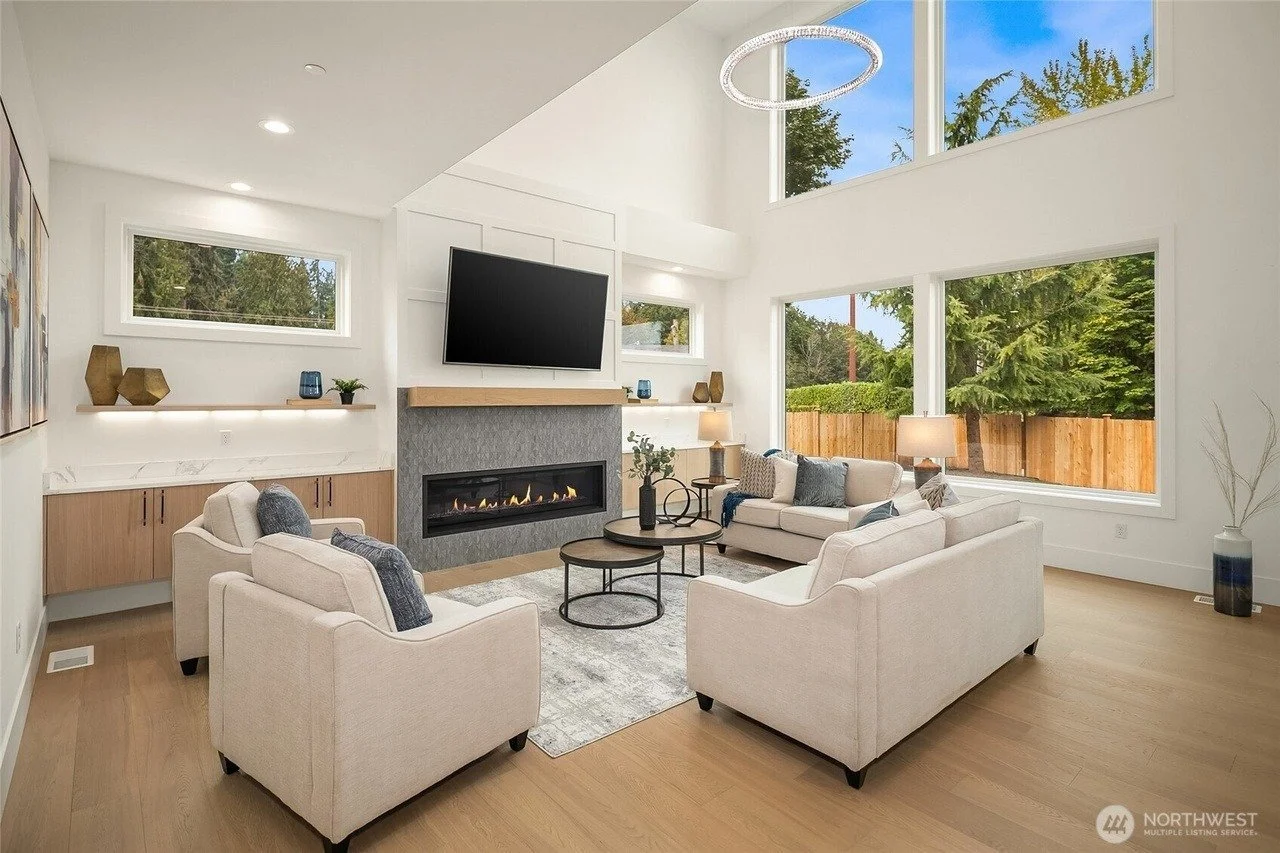 Staged living room with linear fireplace and tall windows in a Rose Hill transitional home, Redmond