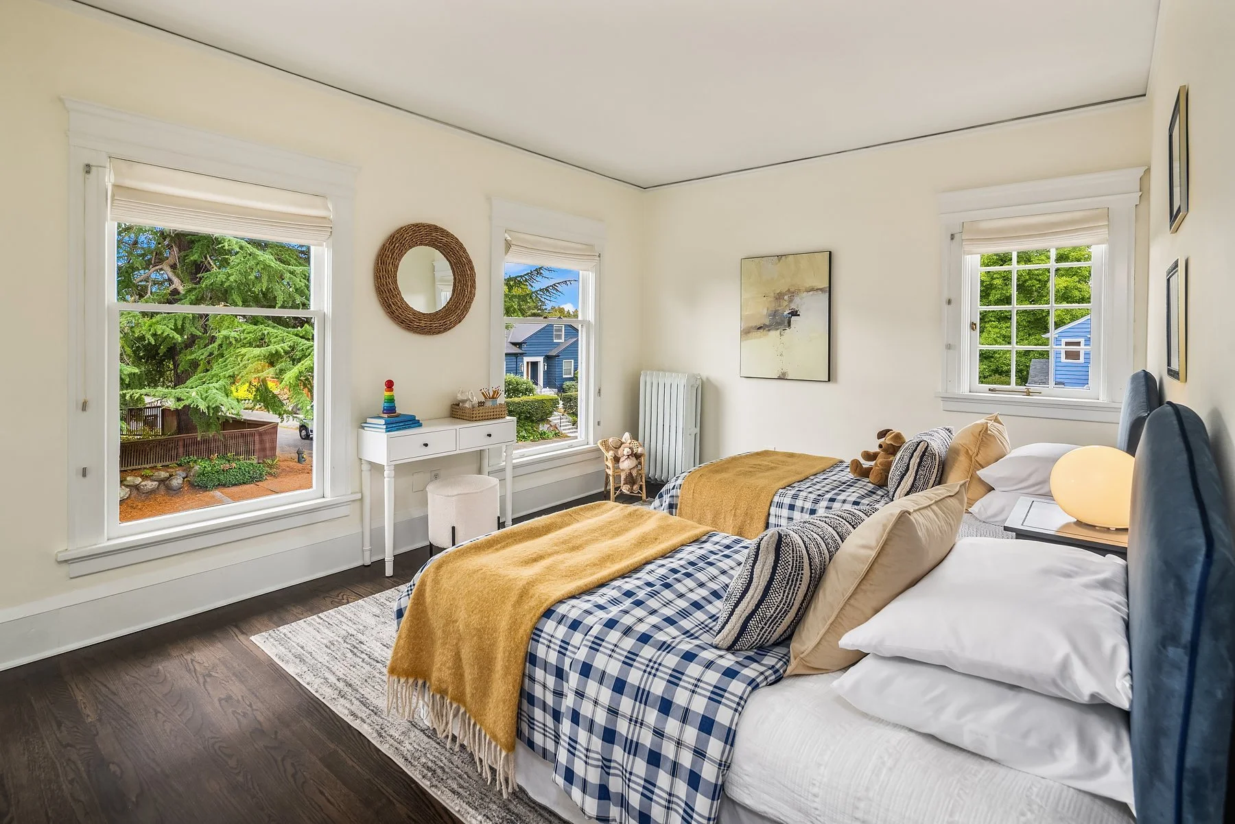 Staged bedroom with plaid and mustard bedding in a Seattle home