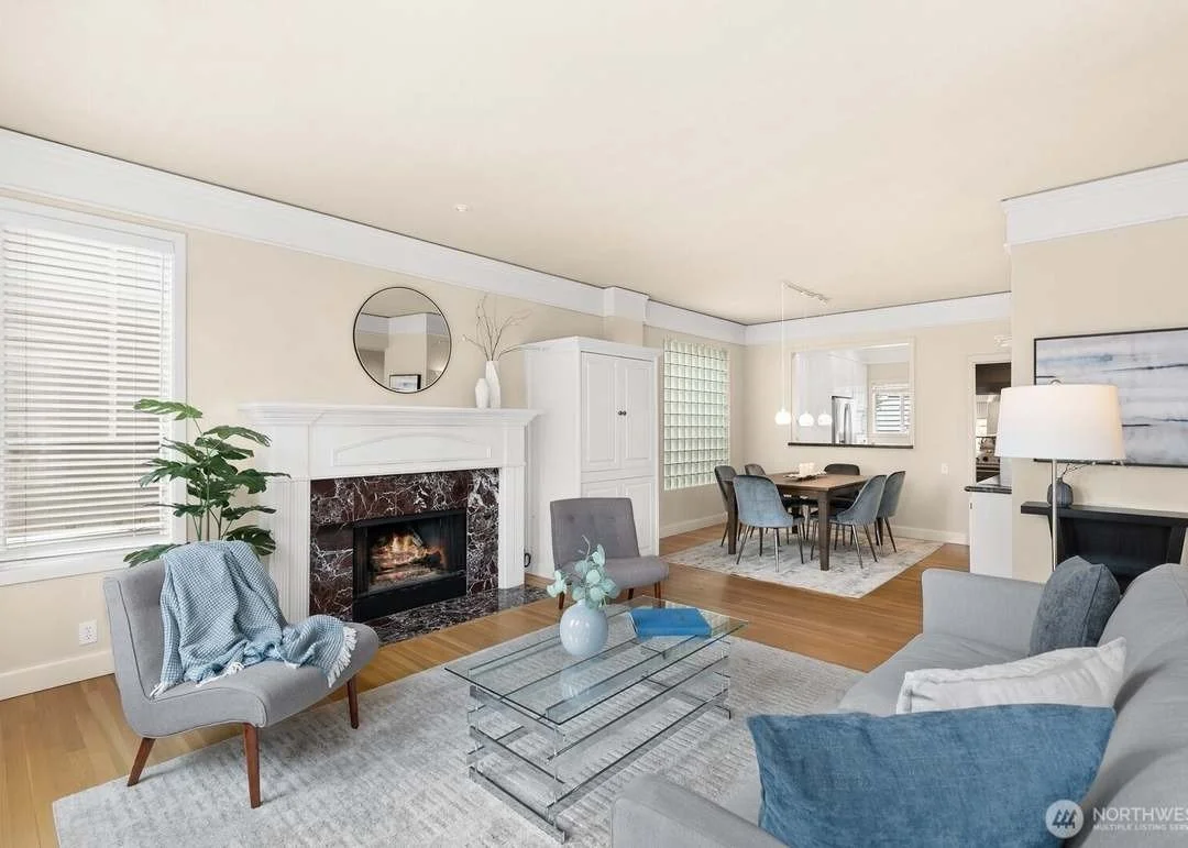 Staged living room with marble fireplace and open dining area in a Madison Park townhouse, Seattle