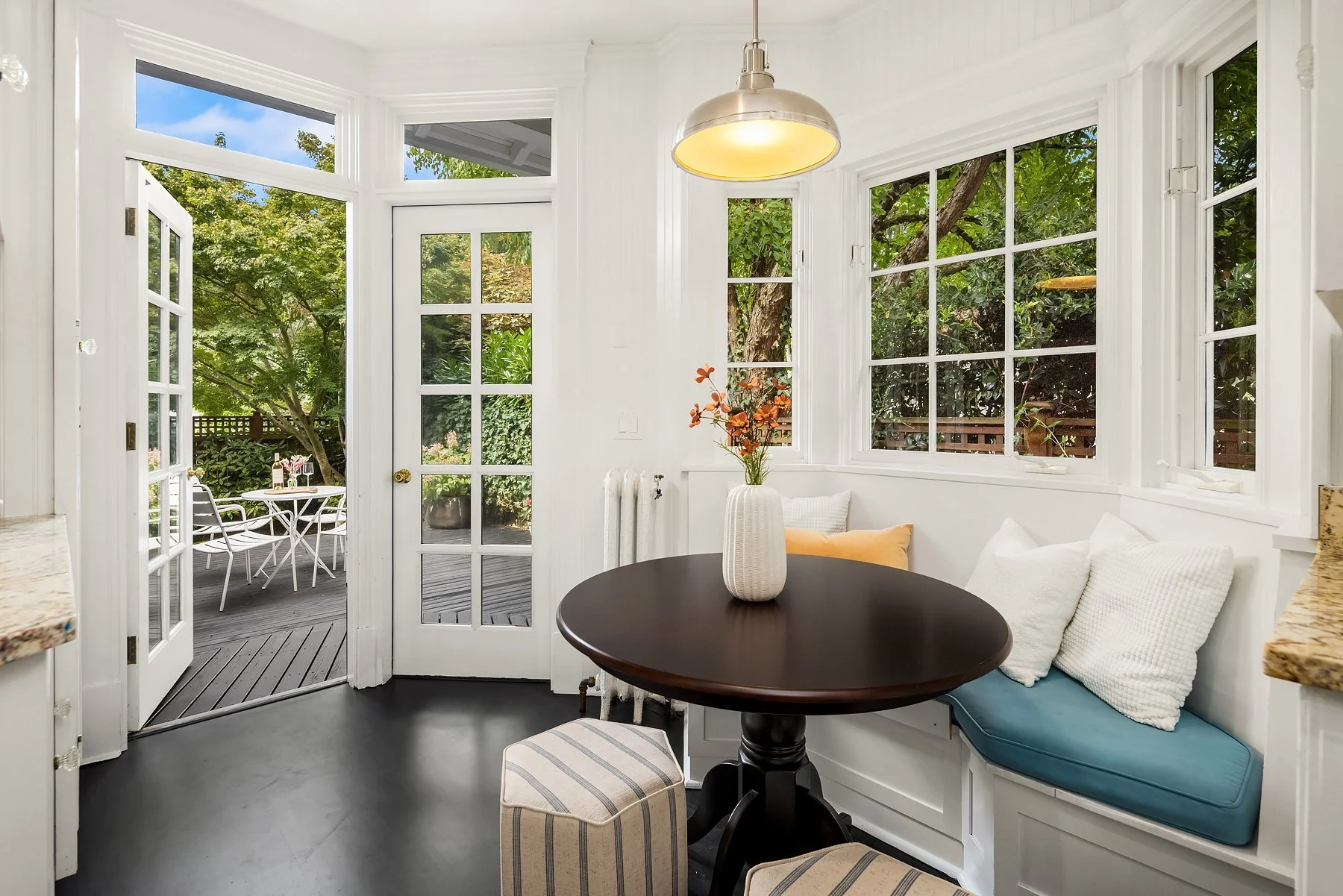 Staged breakfast nook with round table and blue cushioned bench in a Seattle home