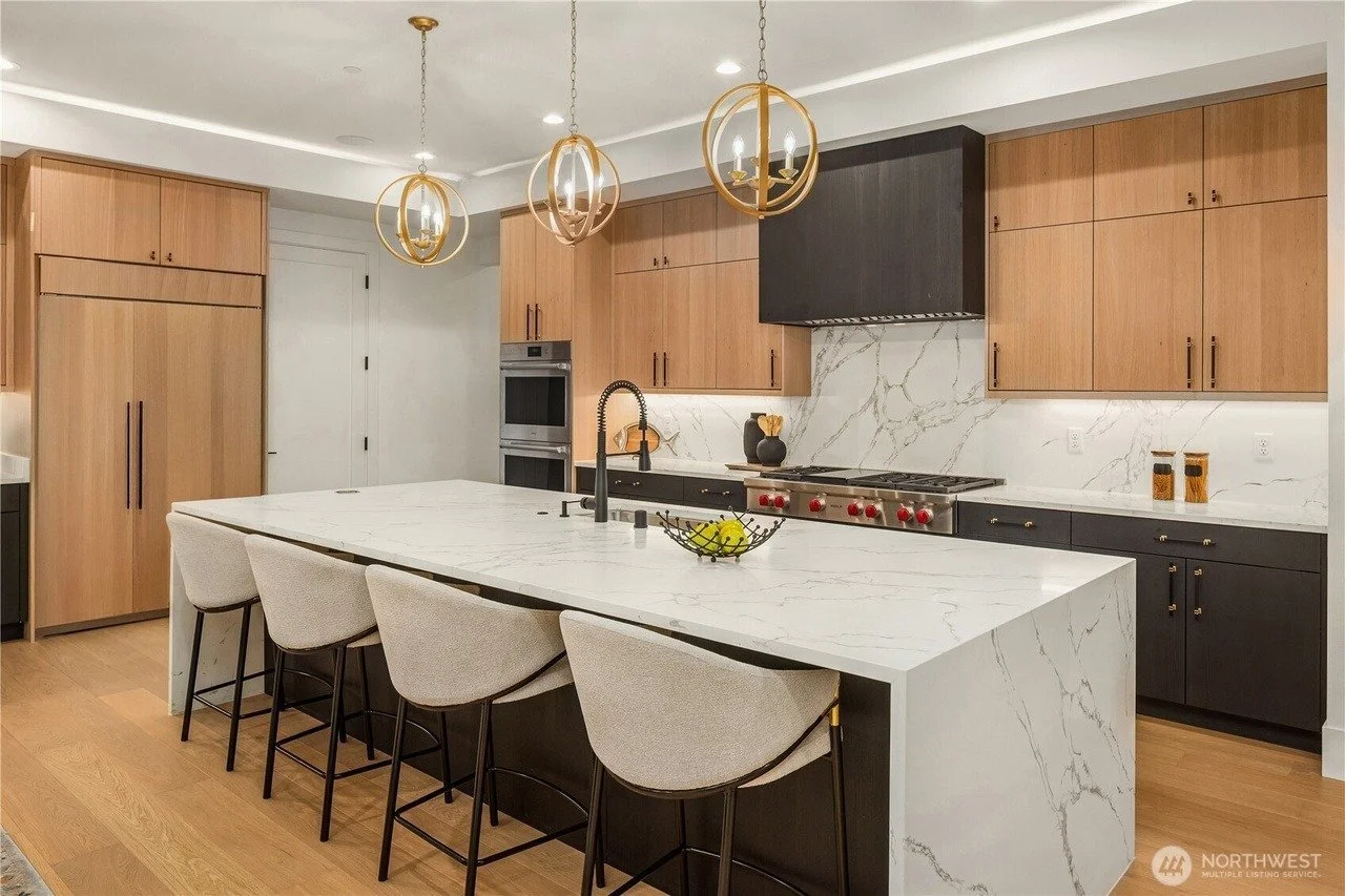 Open kitchen with waterfall island and staged counter stools in a Rose Hill transitional home, Redmond