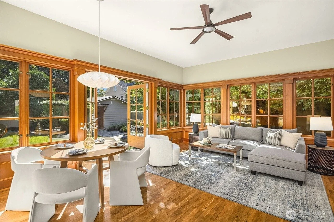 Staged family room and dining area with wood-framed windows in a classic Madison Park home, Seattle