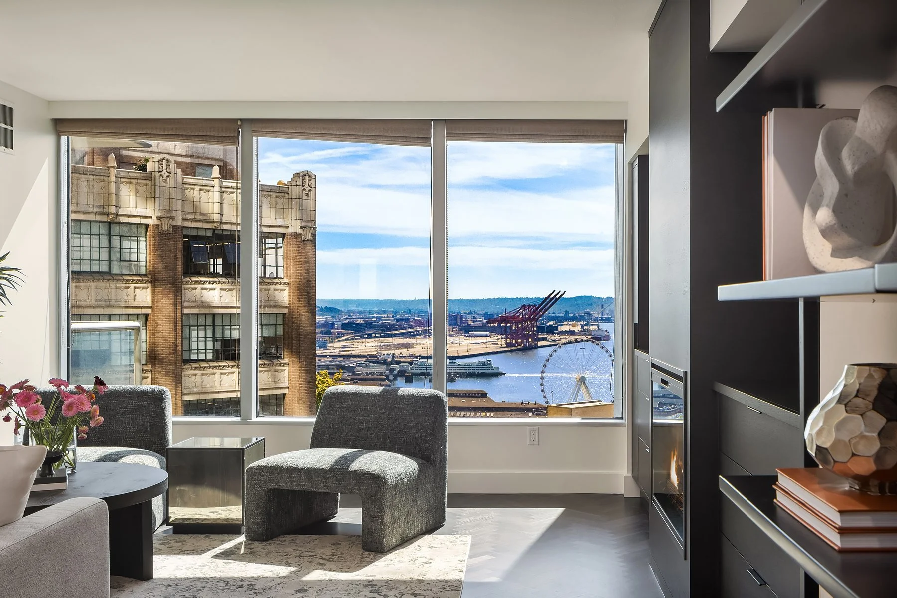Elliott Bay view through corner windows from a staged sitting area in a downtown Seattle condo