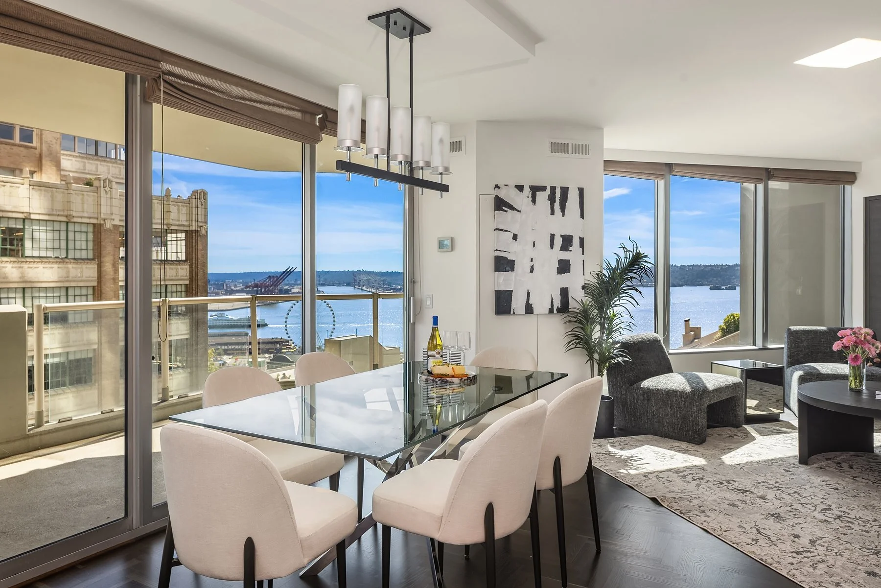 Staged dining area with chandelier and floor-to-ceiling water views in a downtown Seattle condo