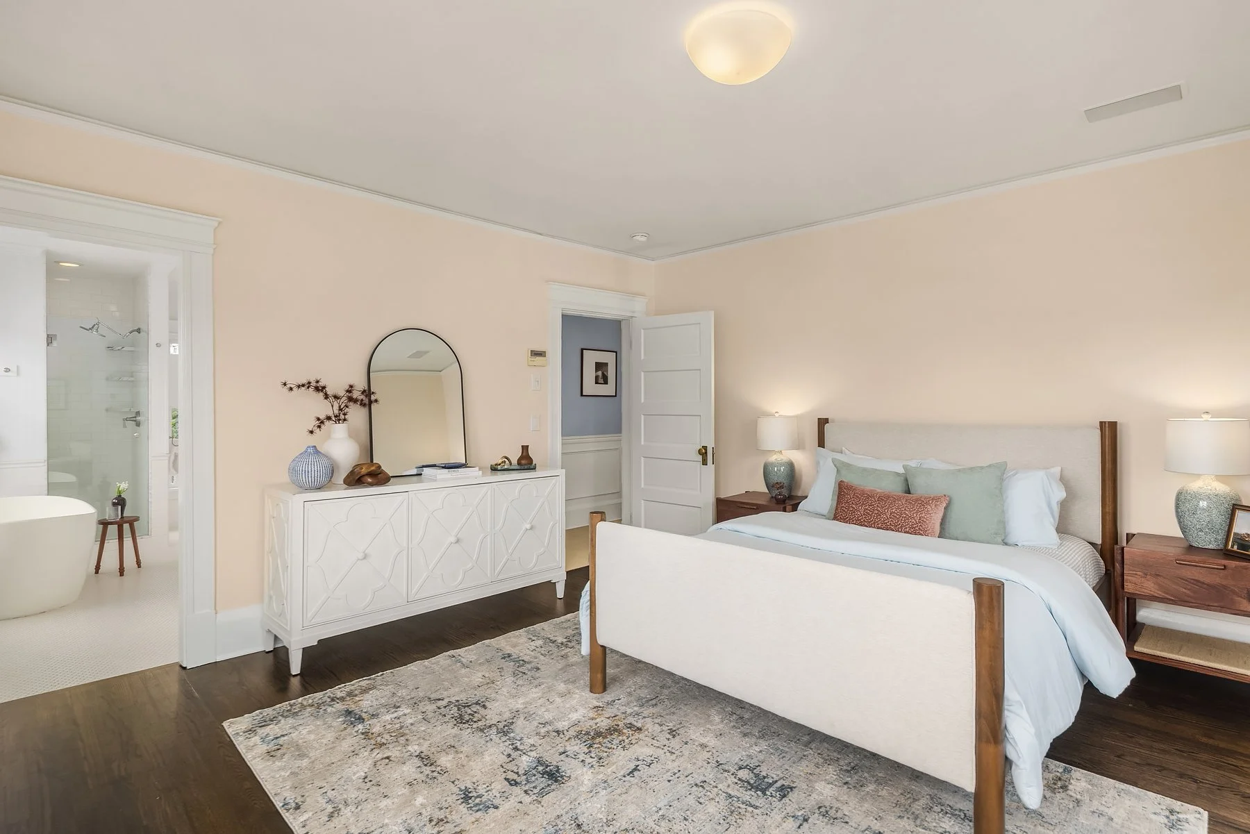 Staged bedroom with blush walls and white bed frame in a Seattle home