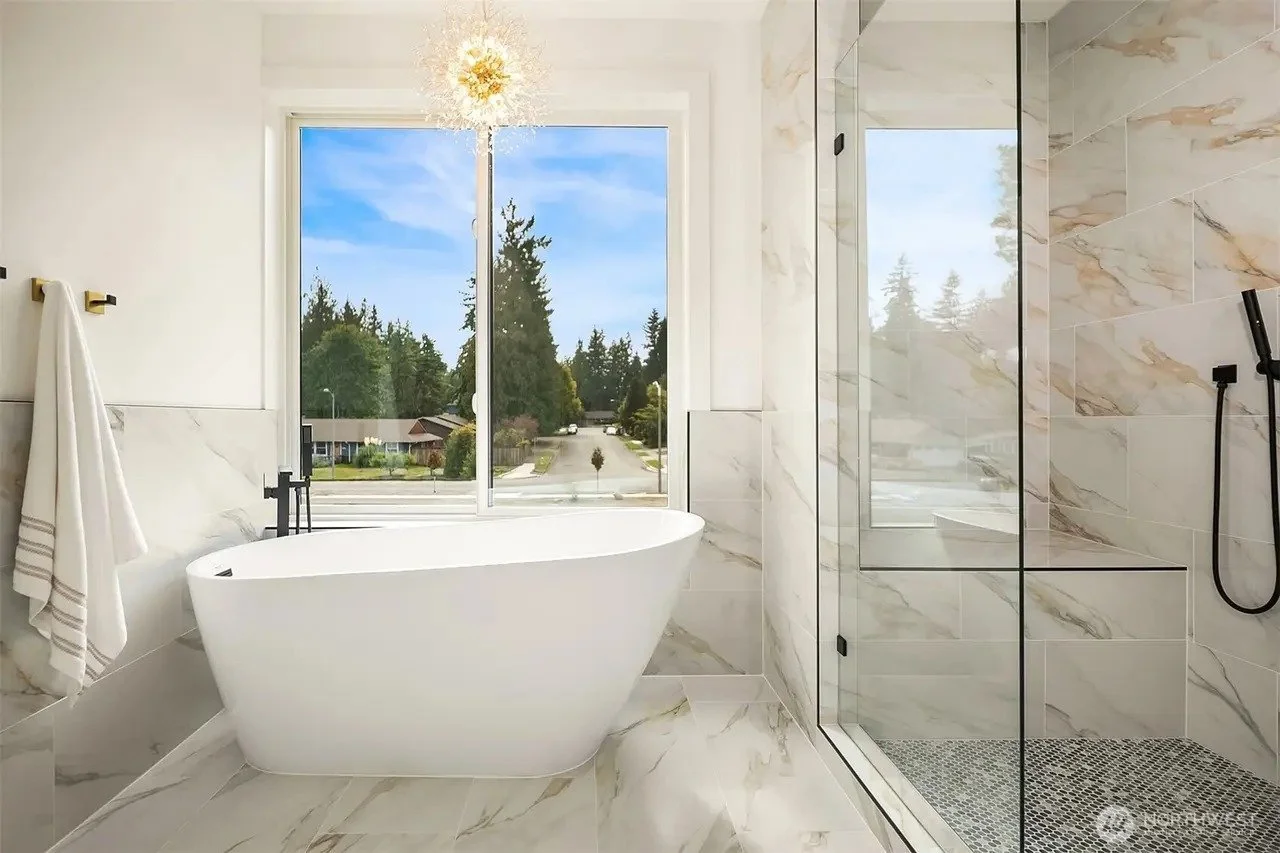 Primary bathroom with freestanding soaking tub and glass shower in a Rose Hill transitional home, Redmond