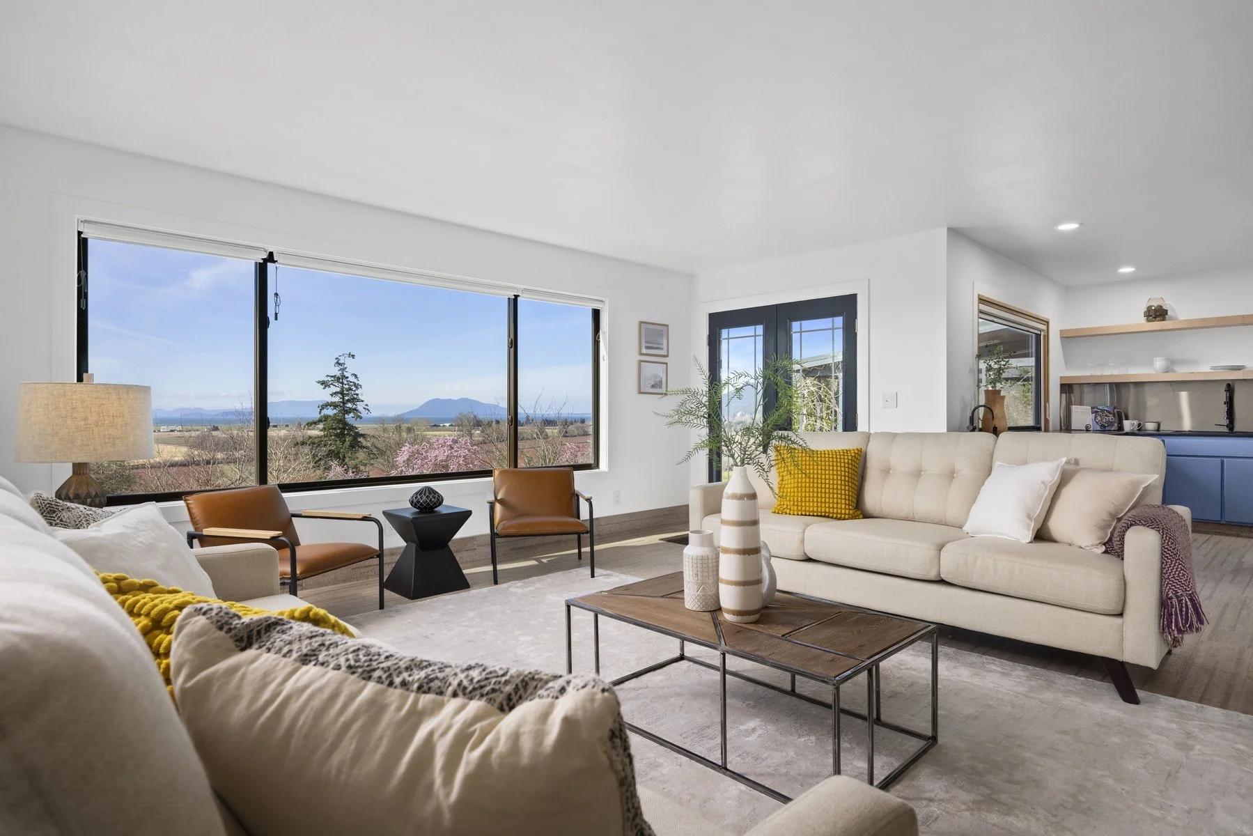 Staged living room with mustard accents and panoramic mountain views in a modern rambler, Bow WA