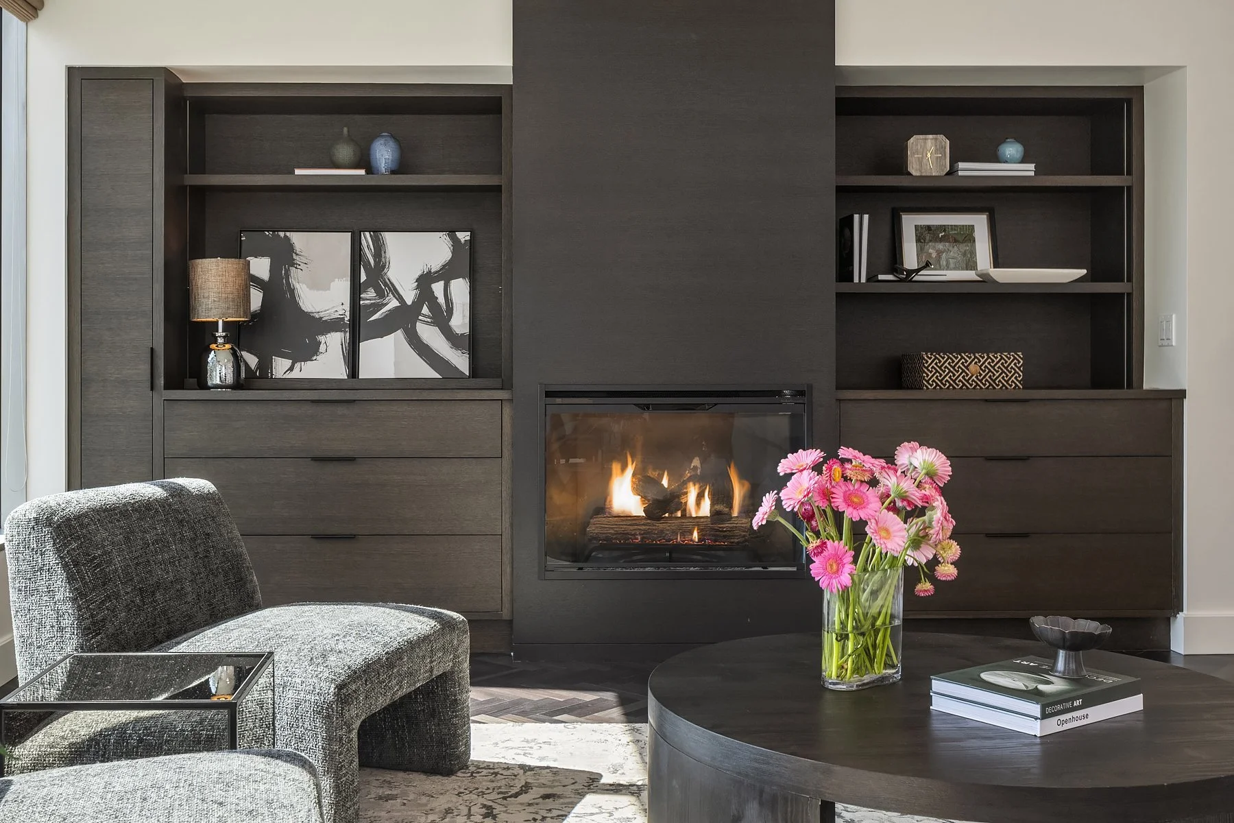 Fireplace wall with dark built-ins and fresh flowers in a downtown Seattle condo