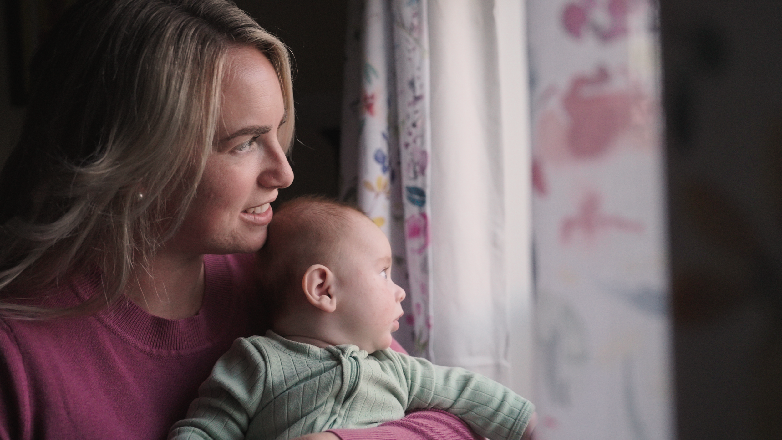 Mother holding her 3-month-old baby at home — documentary-style family film by Louisville videographer Tara O’Brien capturing real motherhood moments.