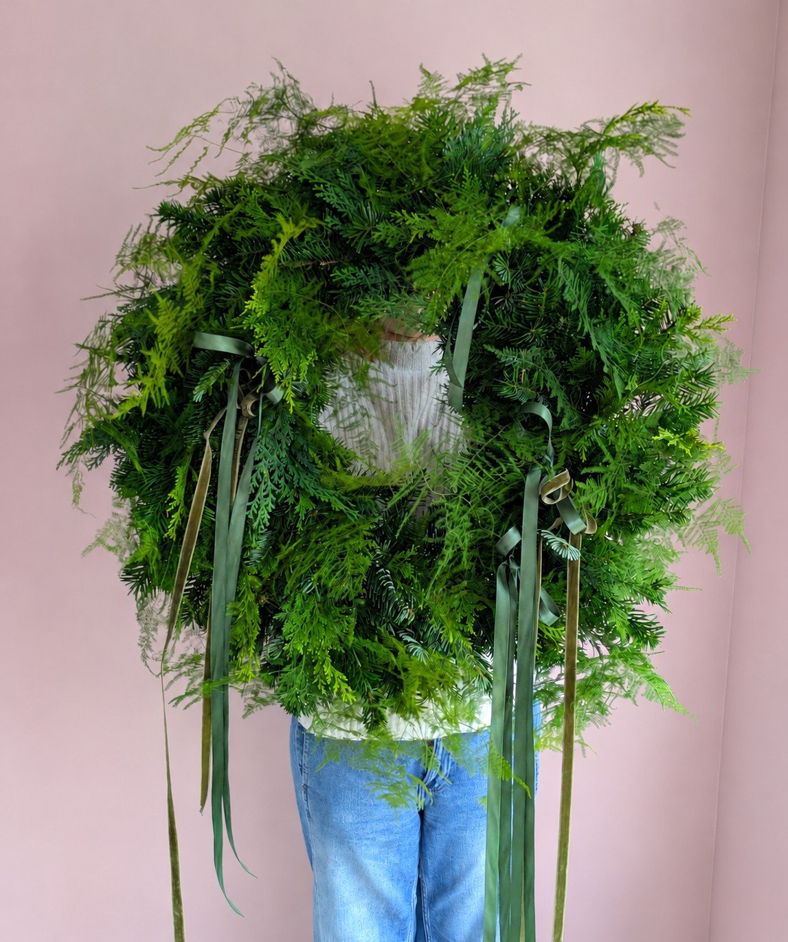 Green wreath against a pink wall.jpg