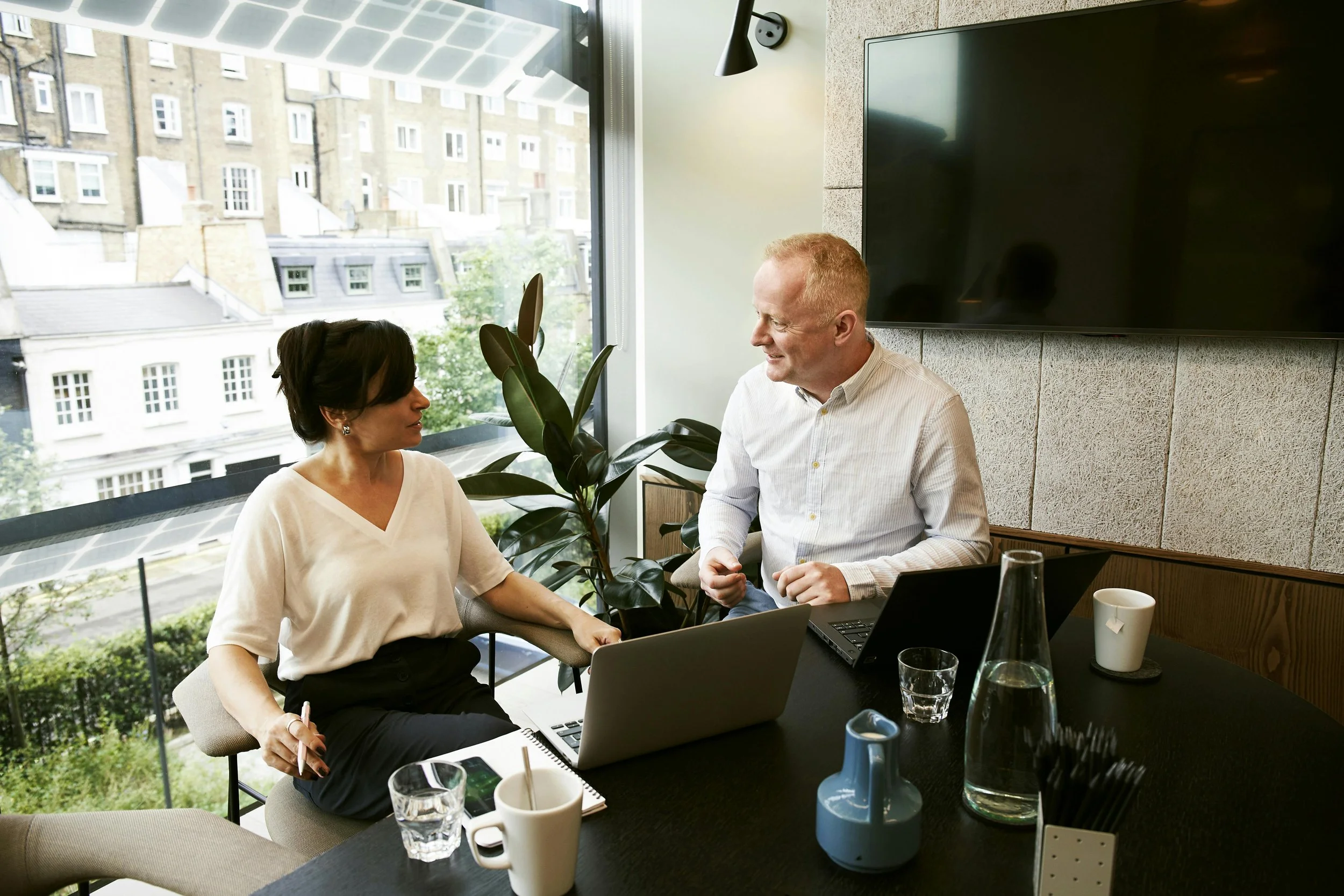 Two leaders engaging a coaching session in a modern office setting, discussing personal performance